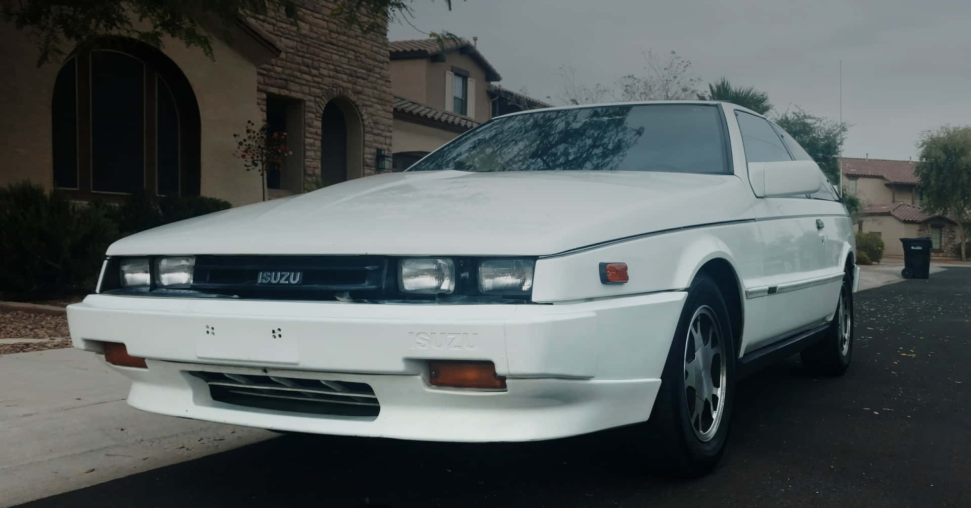 Isuzu Impulse Blanche Garée Dans Un Quartier Résidentiel Fond d'écran