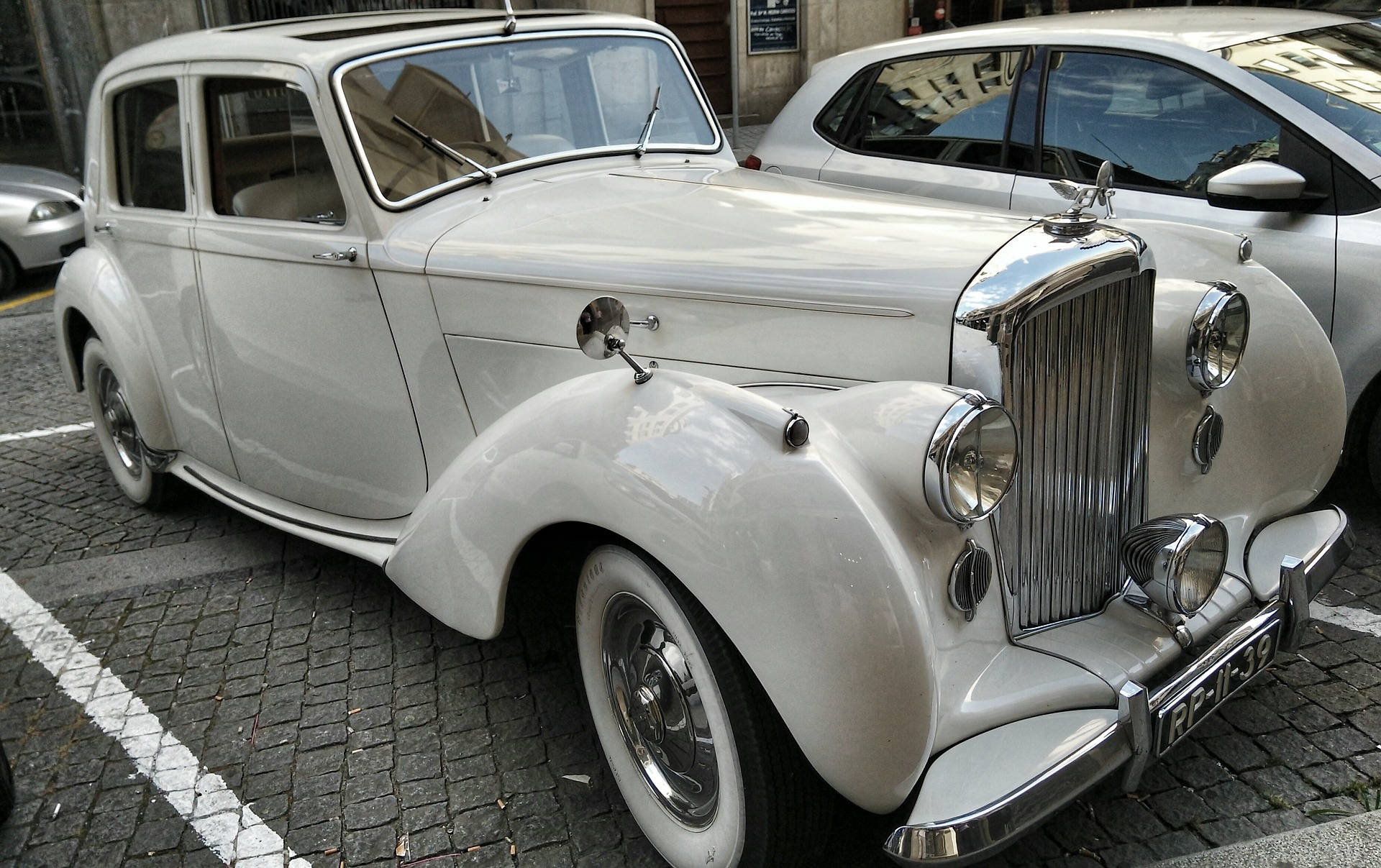Hvide Mark VI Bentley-bilerne konkurrerer over sølvkornet baggrund. Wallpaper