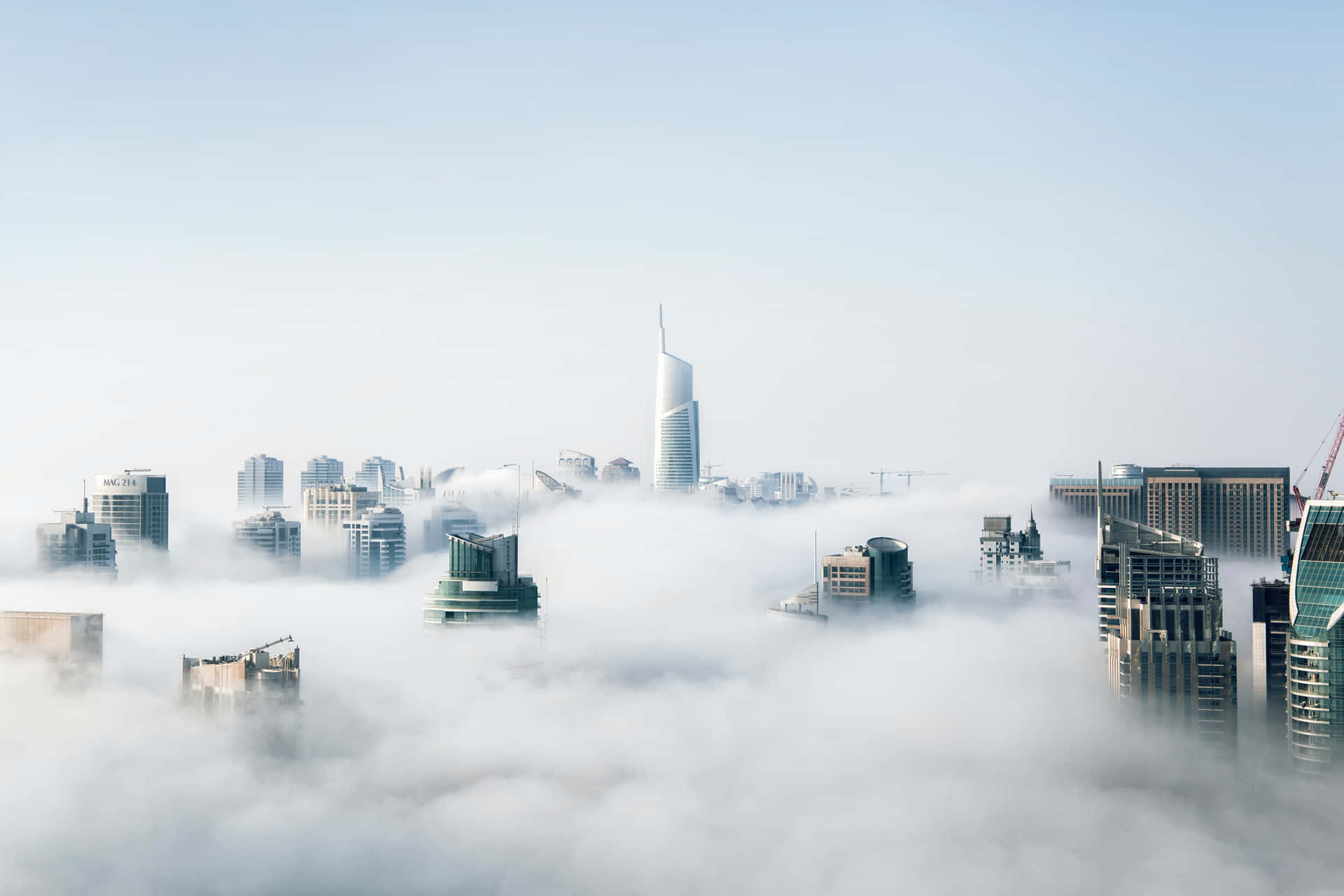 Et by dækket af skyer med høje bygninger. Wallpaper