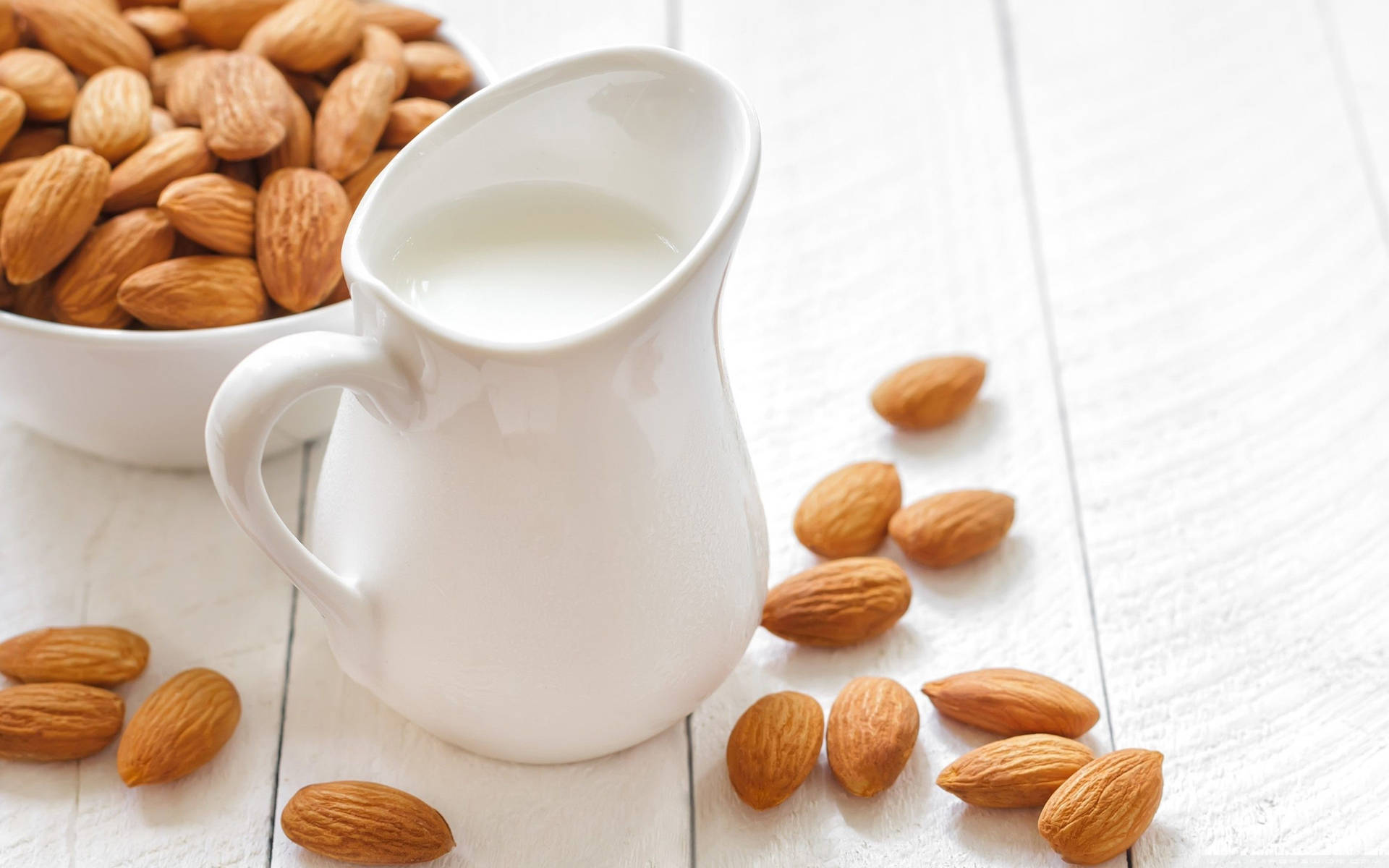 White Pitcher Of Almond Milk With Nuts Wallpaper