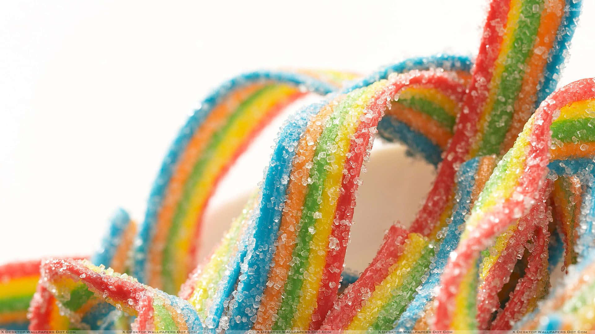 A Close Up Of A Rainbow Colored Candy Wallpaper