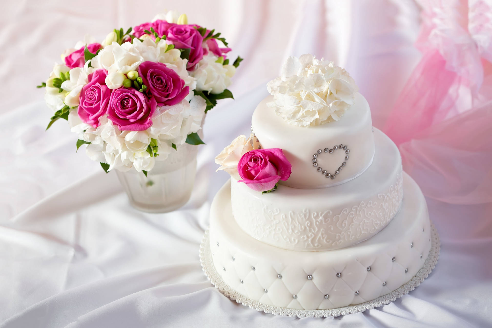 White Round Wedding Cake With Beads Near Roses Wallpaper