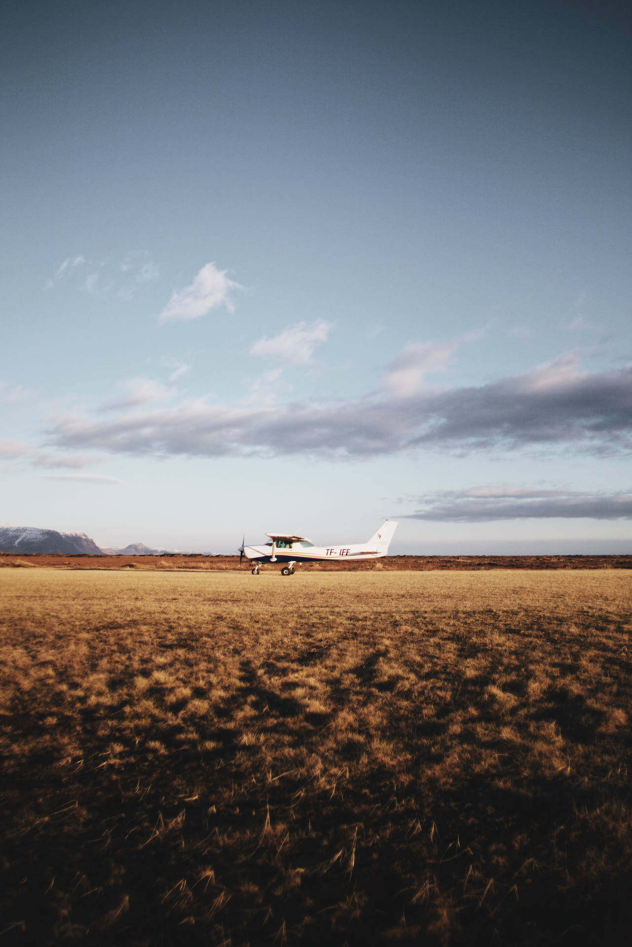 A Tinny White Plane Waiting for Takeoff in Open Field Wallpaper