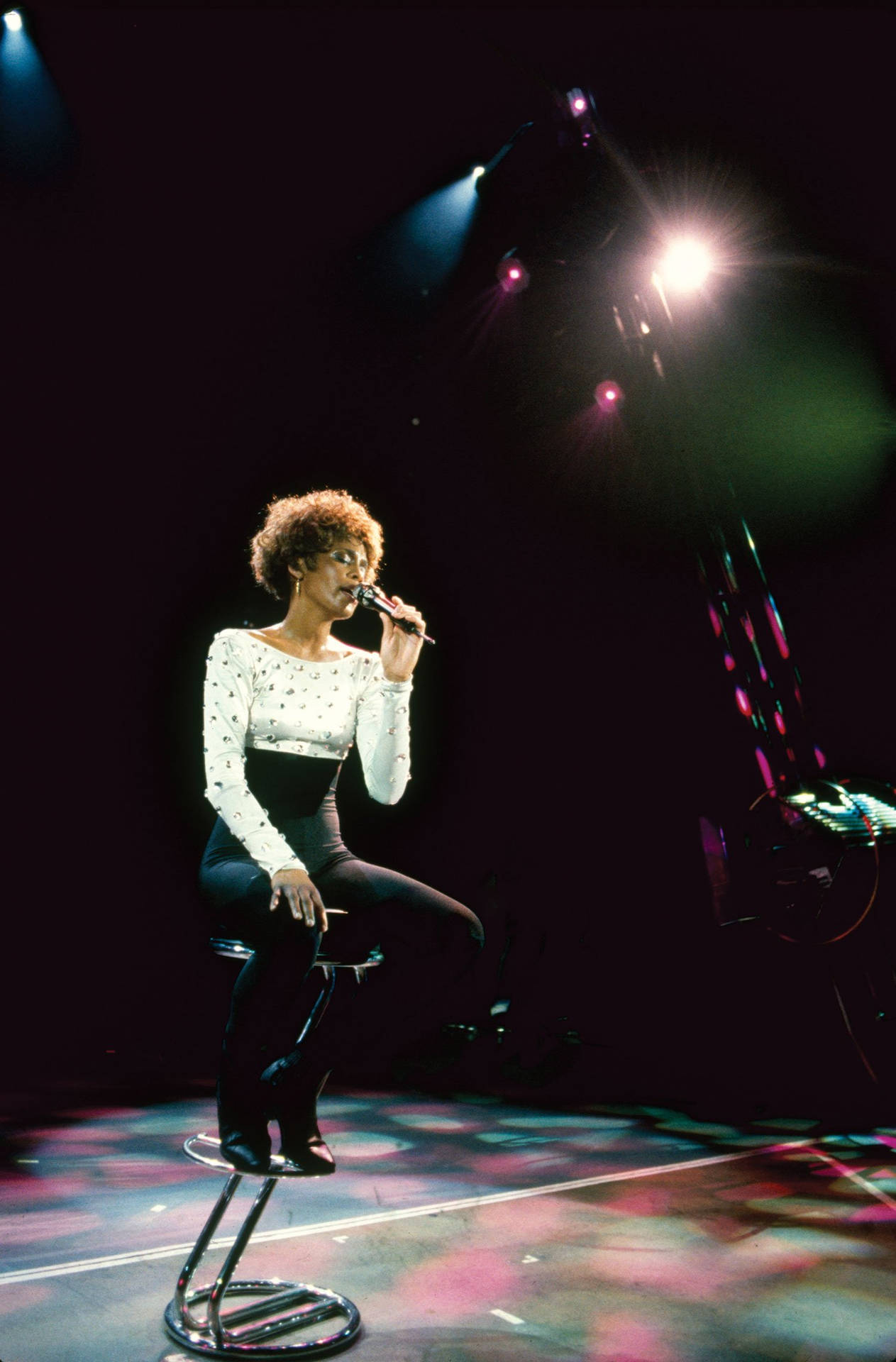 Whitney Houston Sitting On Stage Background