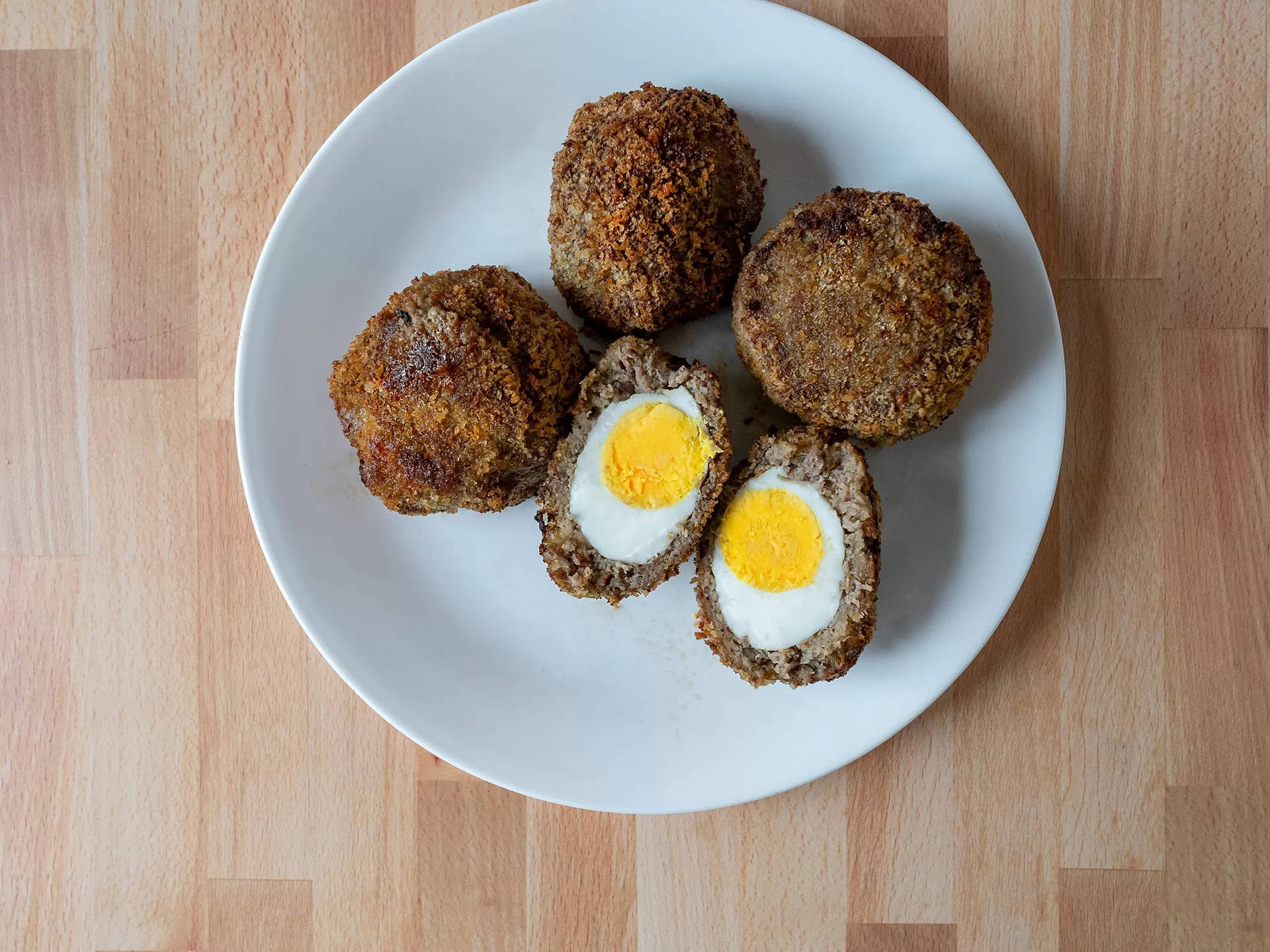 Whole And Sliced Traditional British Scotch Eggs Dish Wallpaper