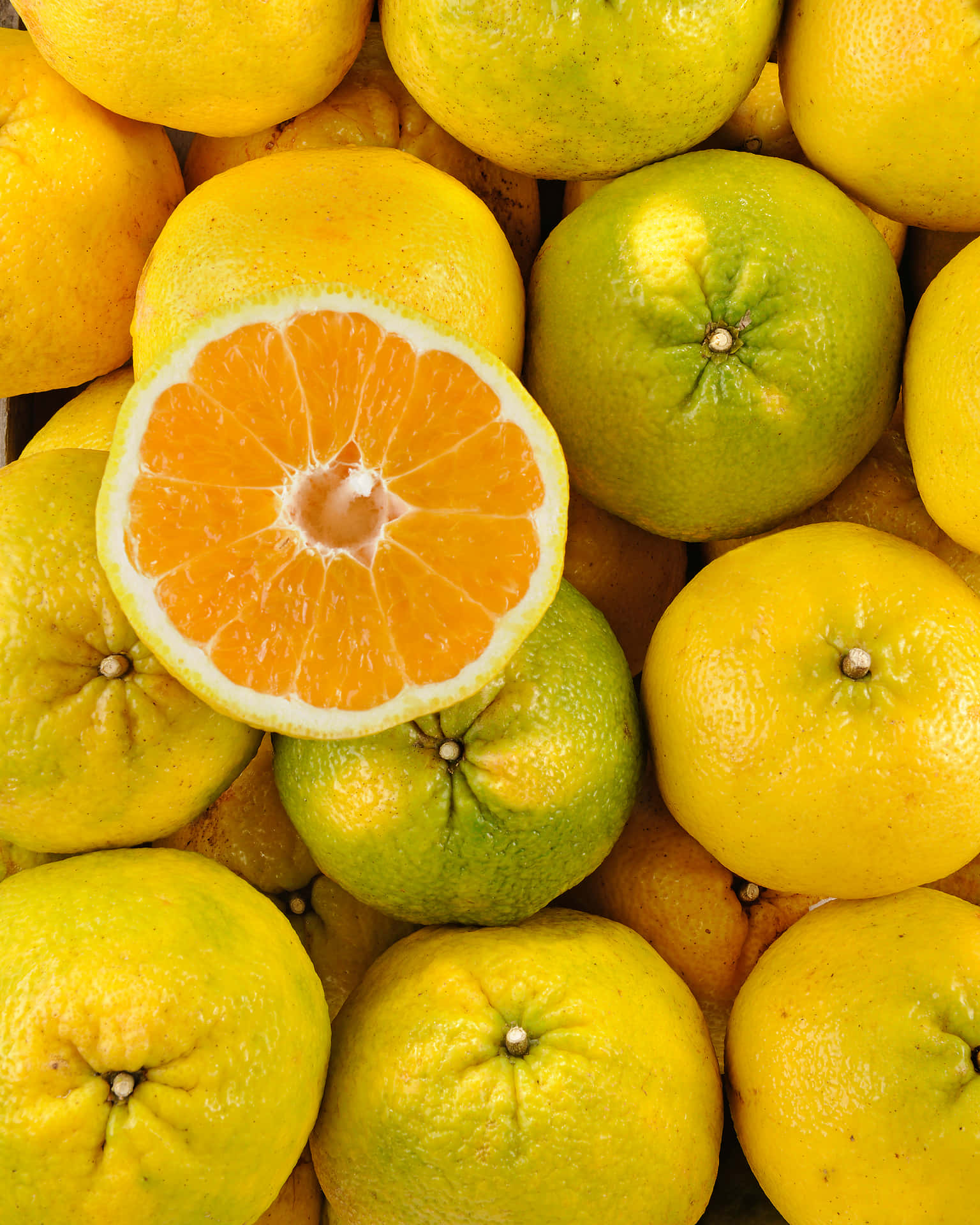 A Refreshing Display of Whole and Sliced Ugli Fruits Wallpaper