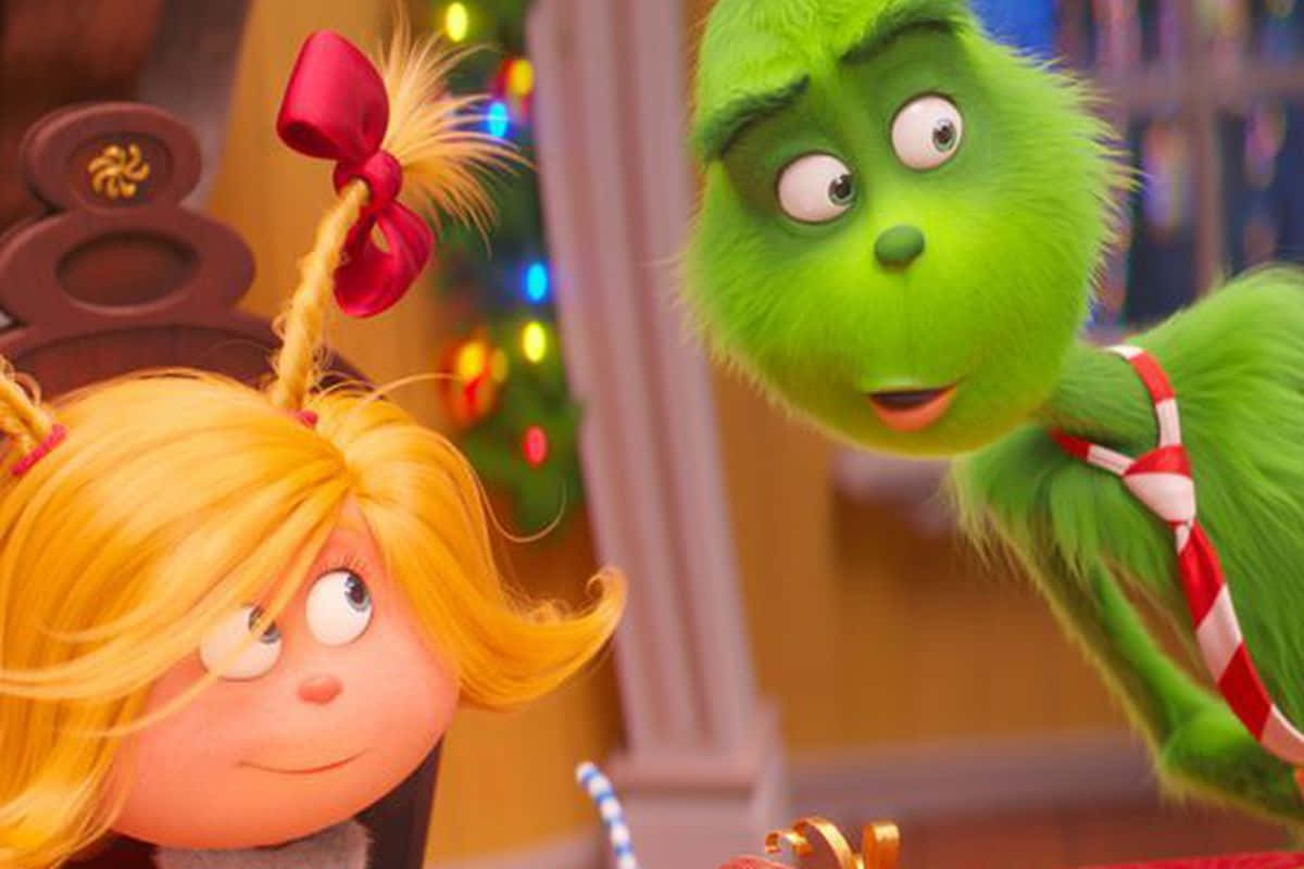 The Grinch And The Girl Are Sitting At A Table Wallpaper