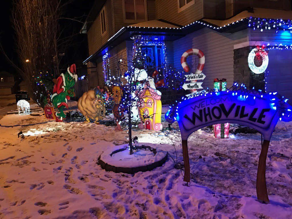 Et hus med julelys og dekorationer i sneen Wallpaper