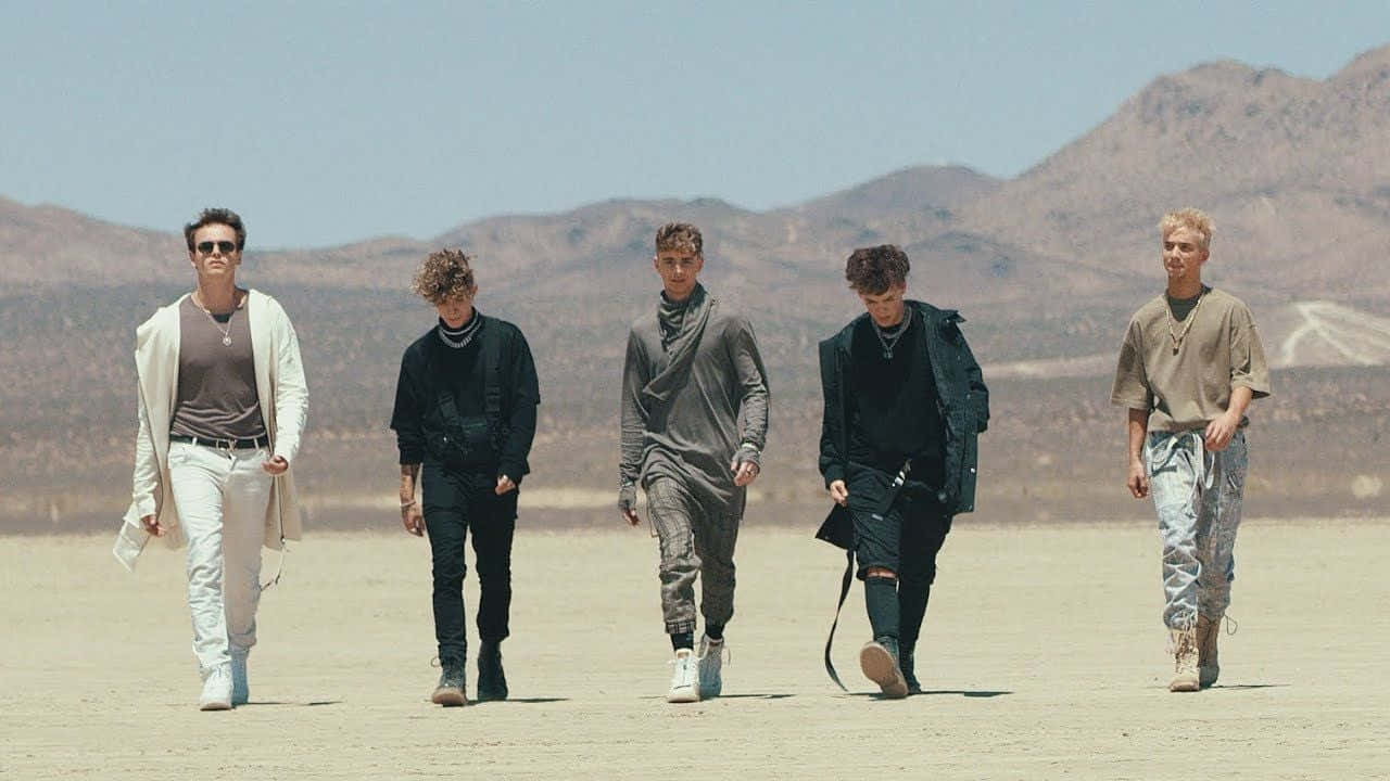 A Group Of Men Walking In The Desert Wallpaper