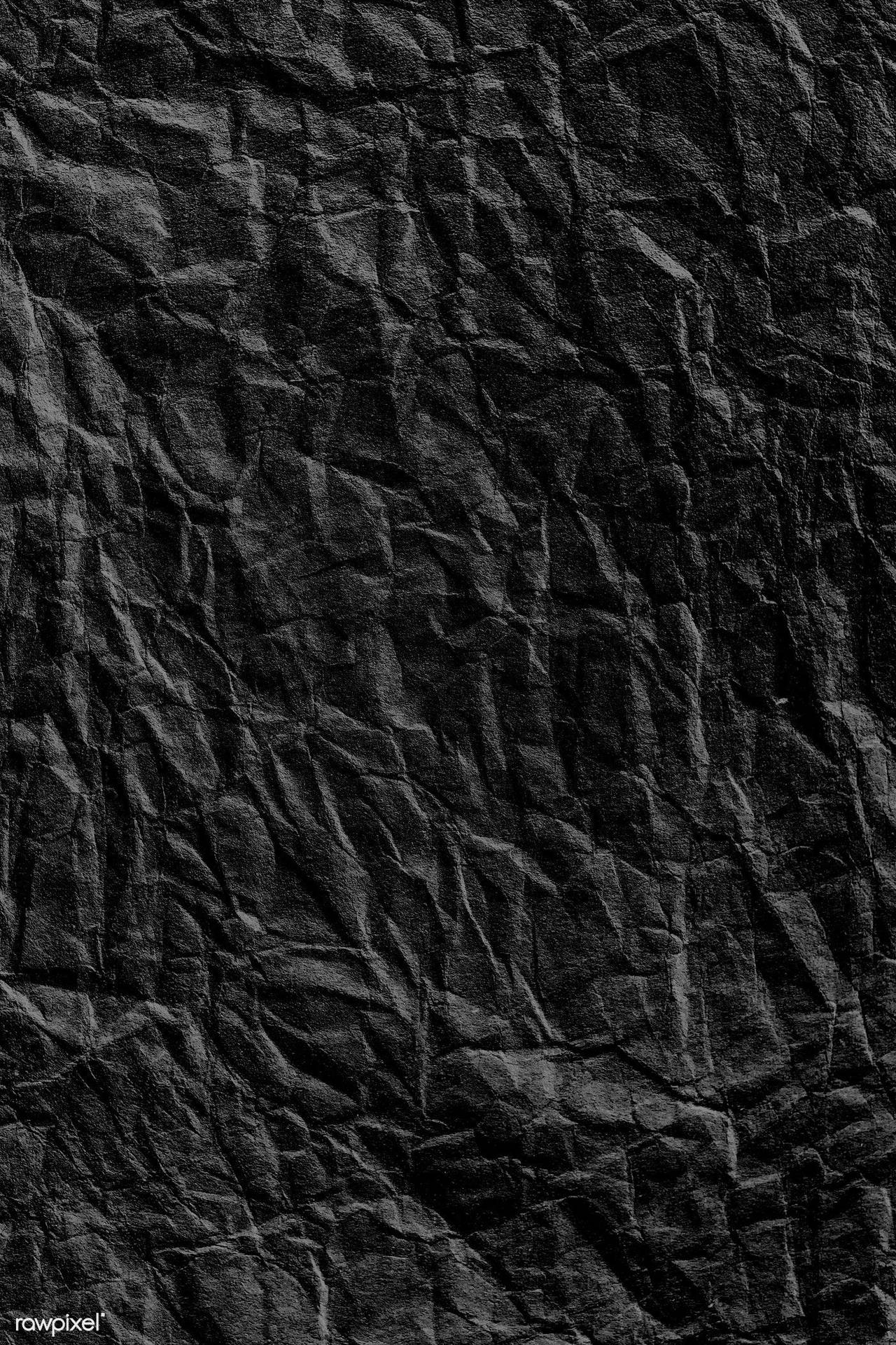 Caption: Dark Intricacy: A Crumpled Black Paper Texture Wallpaper