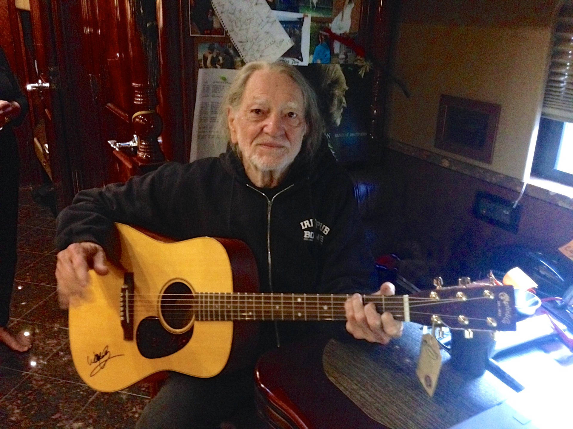 Willie Nelson Playing Guitar At Home Wallpaper