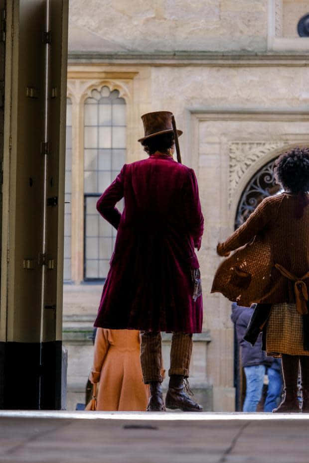 Two People In Costumes Walking Through An Archway