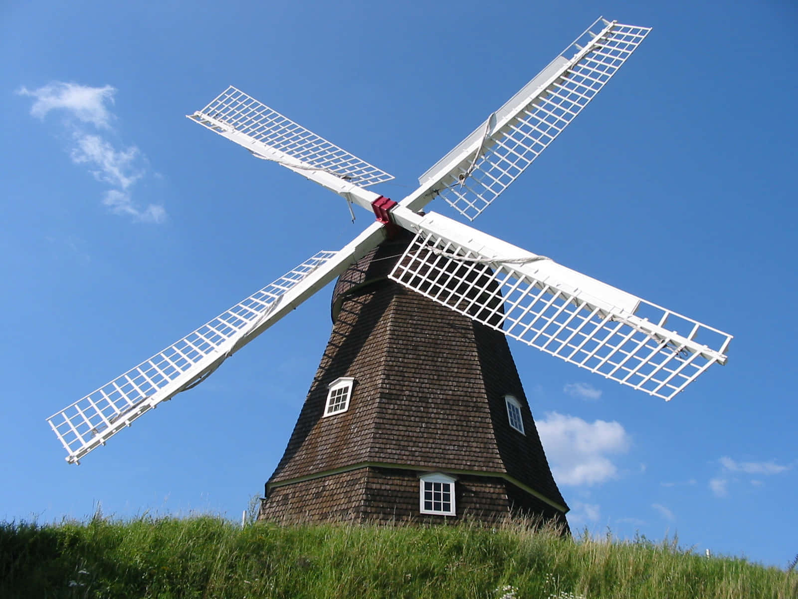 An old, rustic windmill in a peaceful country landscape.