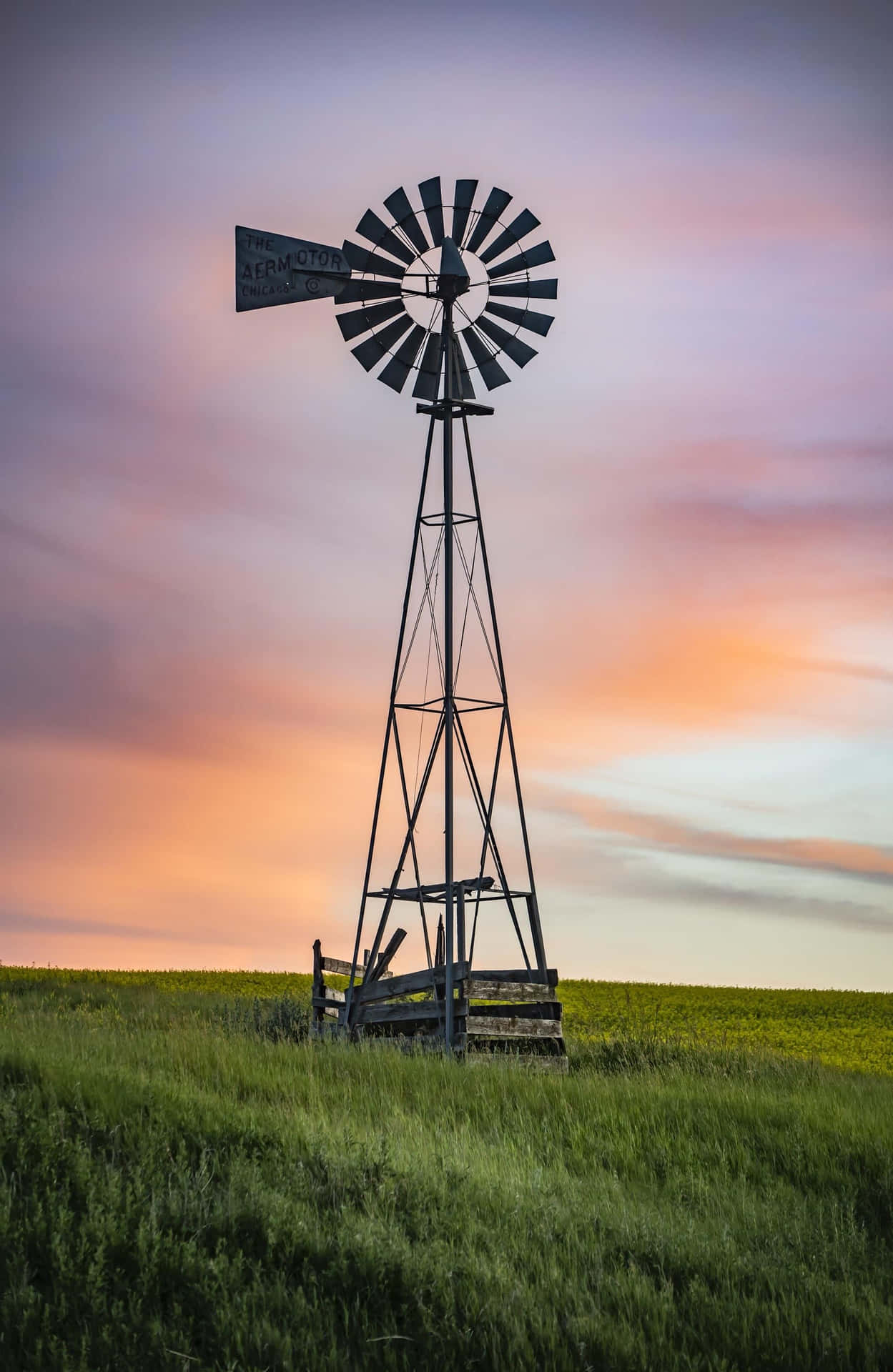 Windmill At Sunset In A Prairie Field