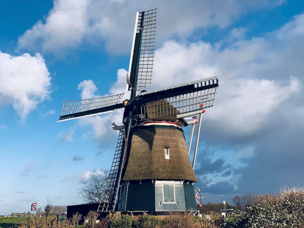 The rolling hills of Netherlands are complete with windmills.