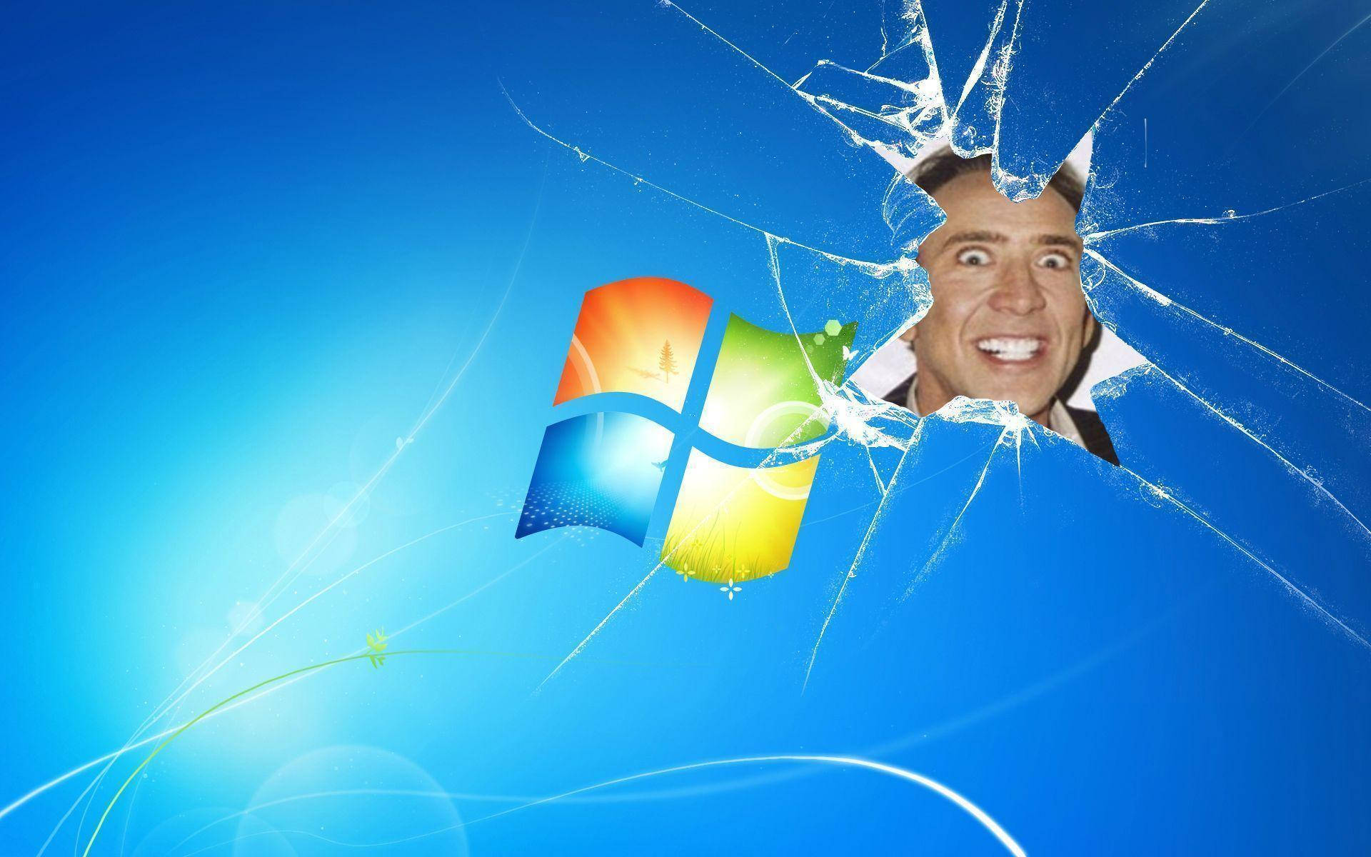Broken windows desktop computer with Nicholas Cage funny face meme showing.