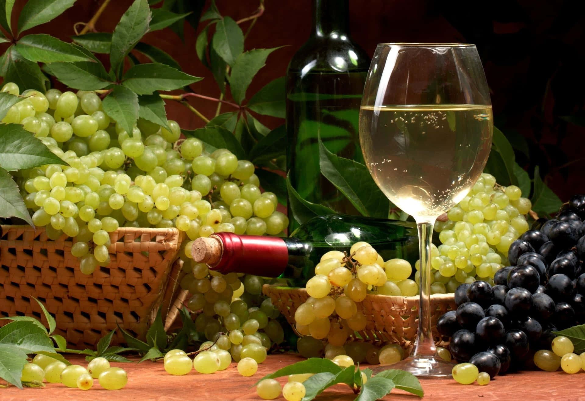 A Glass Of Wine And Grapes On A Table