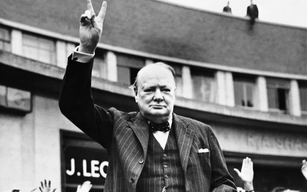 A Man In A Suit Is Waving His Hand In The Air