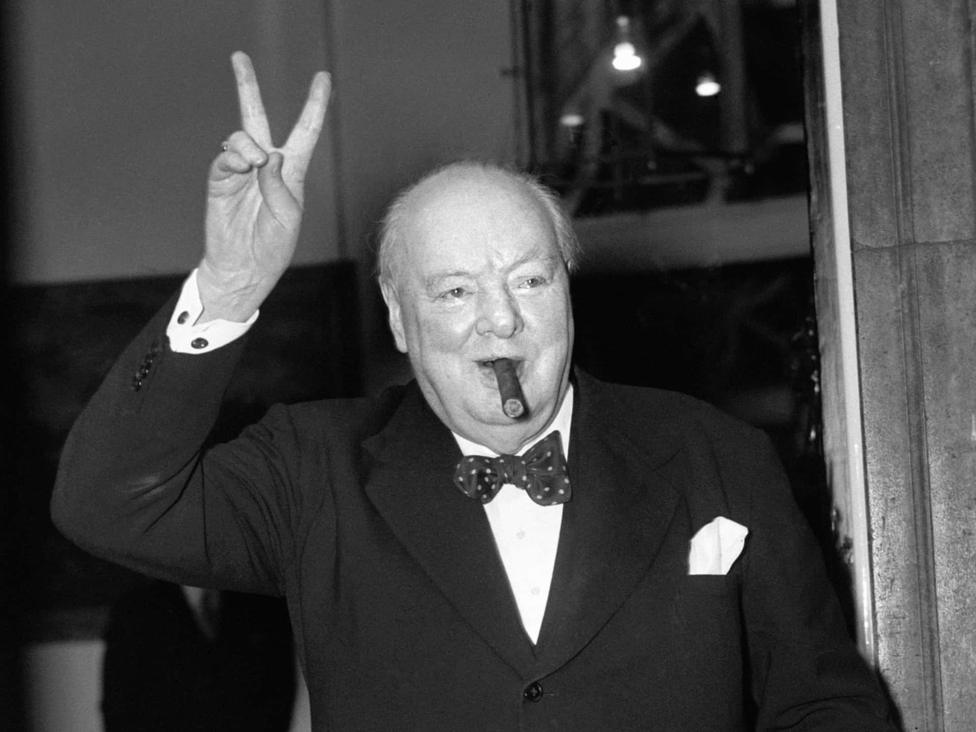 A Man In A Suit Is Making A Peace Sign