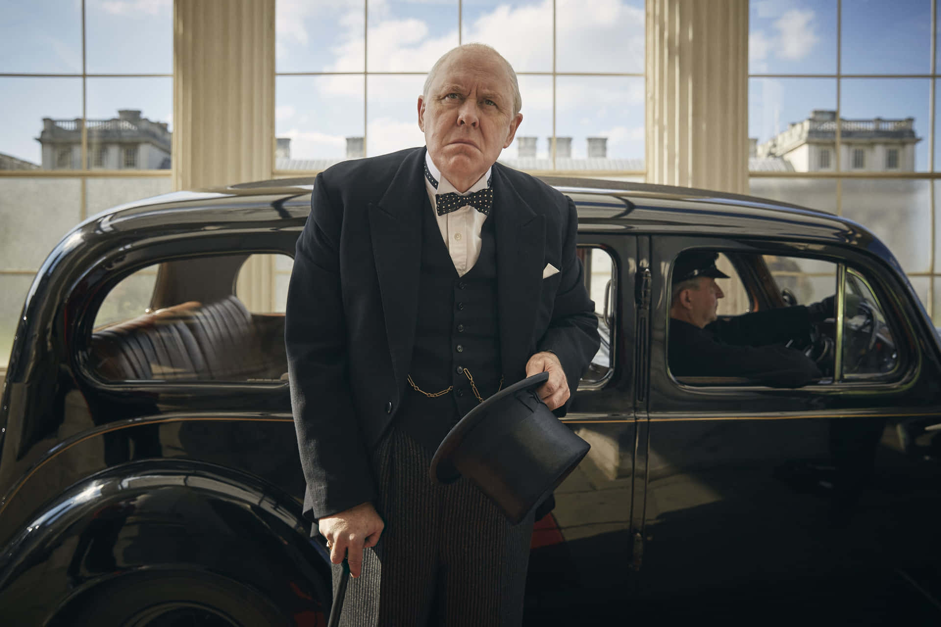 A Man In A Tuxedo Standing Next To A Car