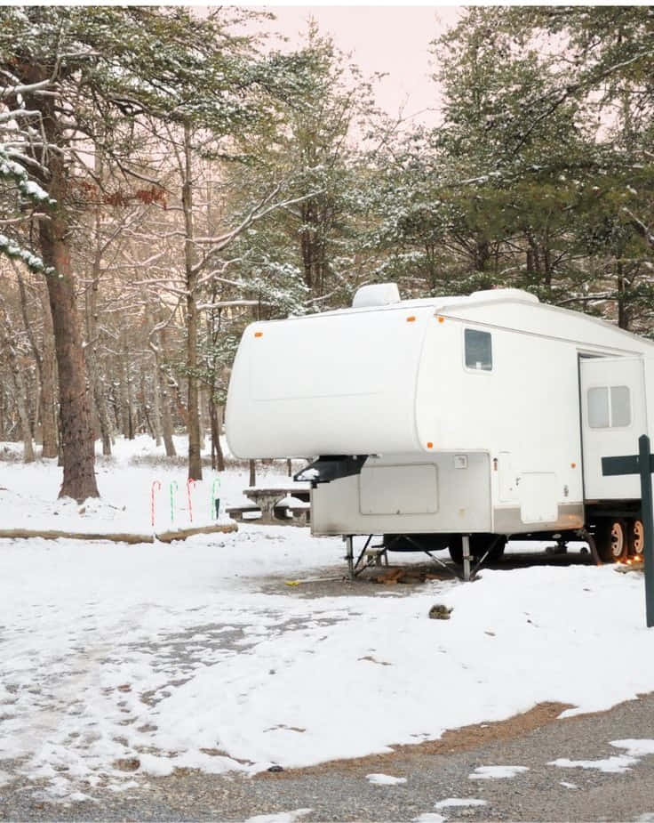 Download A cozy winter campsite amidst serene snow-covered mountains ...