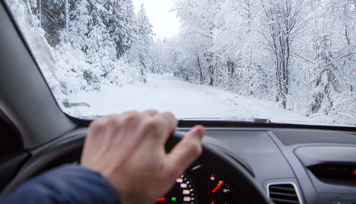 Driving on a snowy road in winter Wallpaper