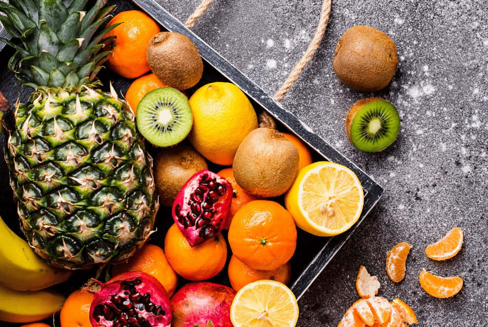 Assorted Winter Fruits Displayed on Snow-Covered Table Wallpaper