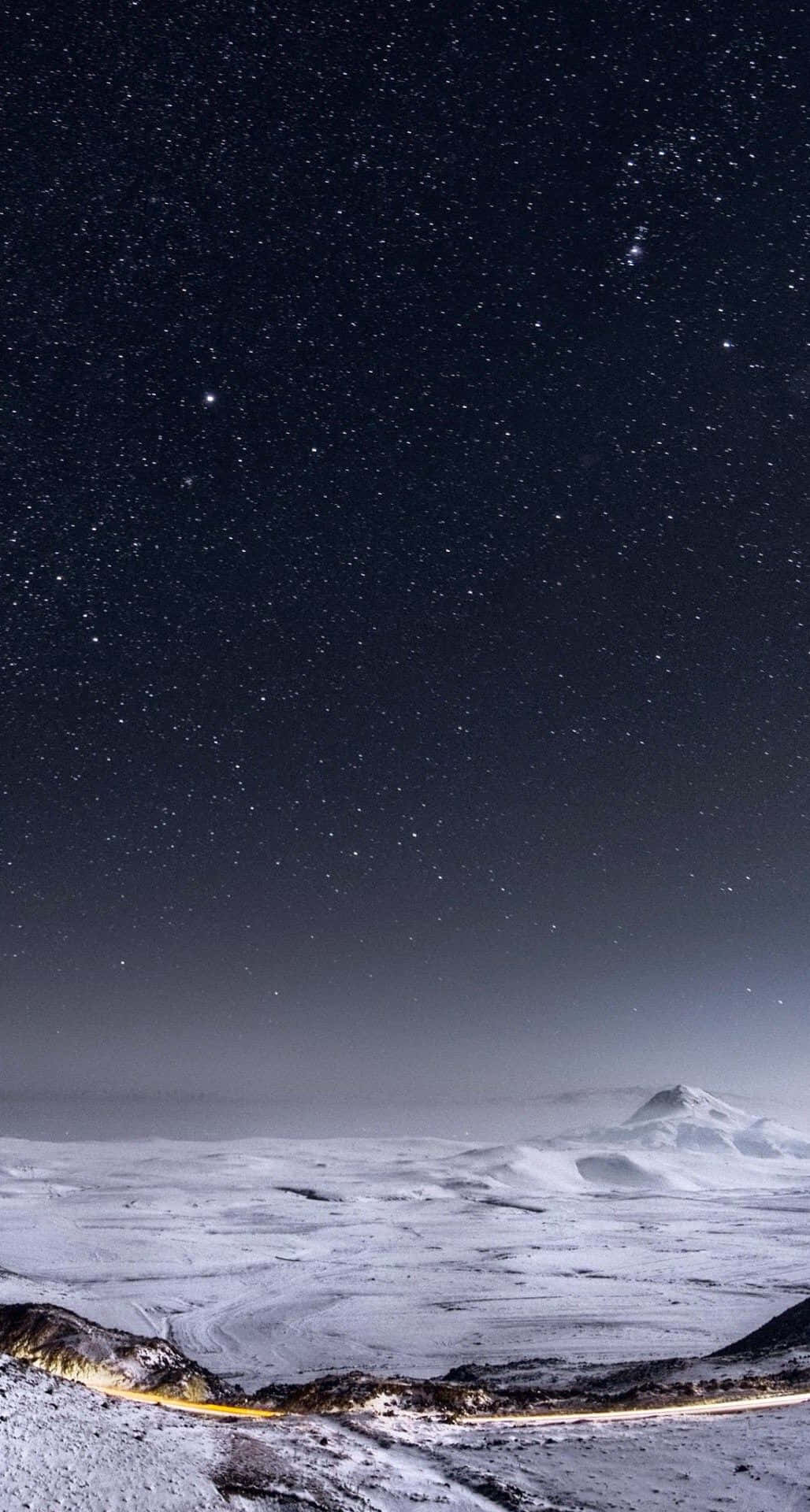 Unpaisaje Nevado Con Una Carretera Y Estrellas Sobre Ella. Fondo de pantalla