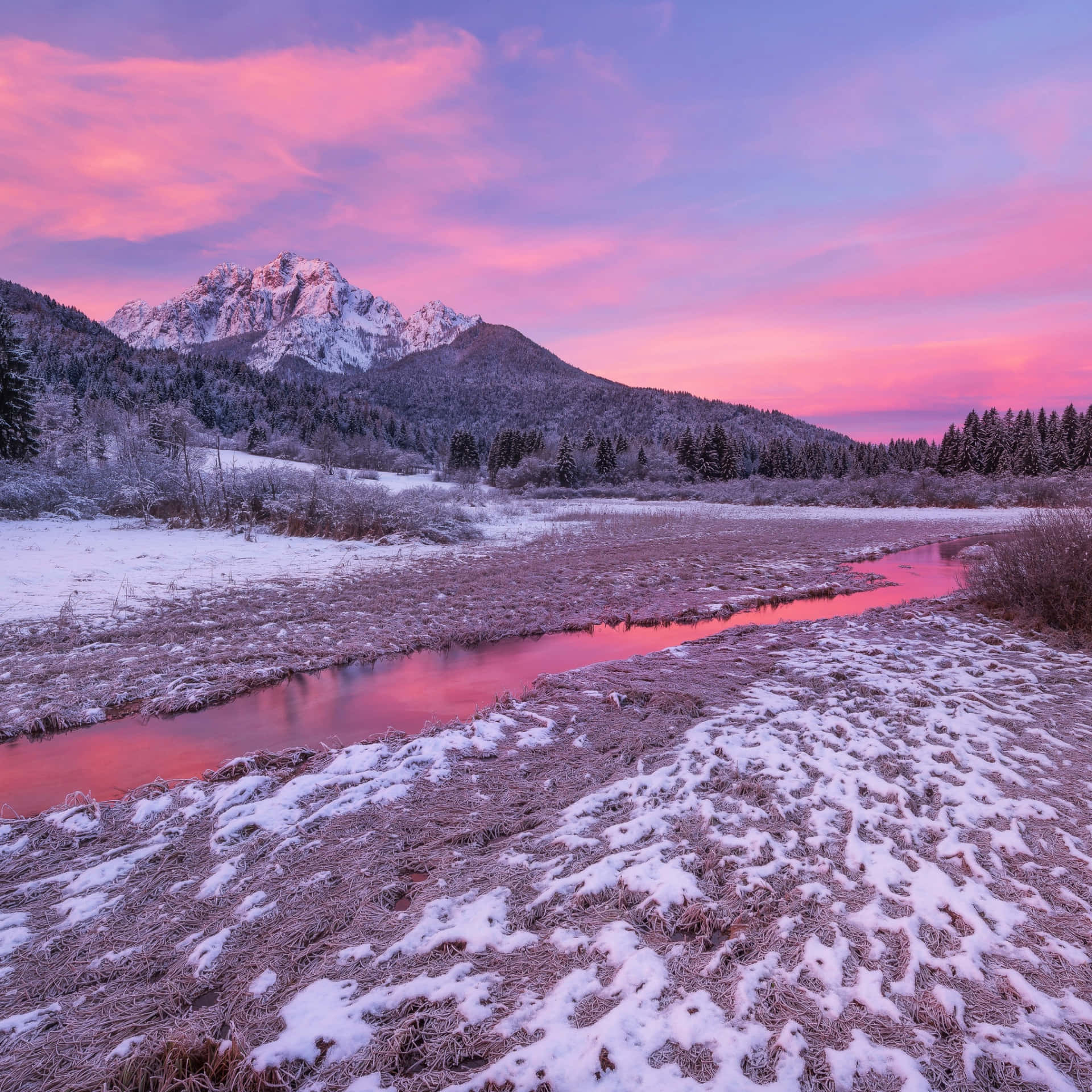 A Snowy Mountain With A Pink Sky And A River Wallpaper