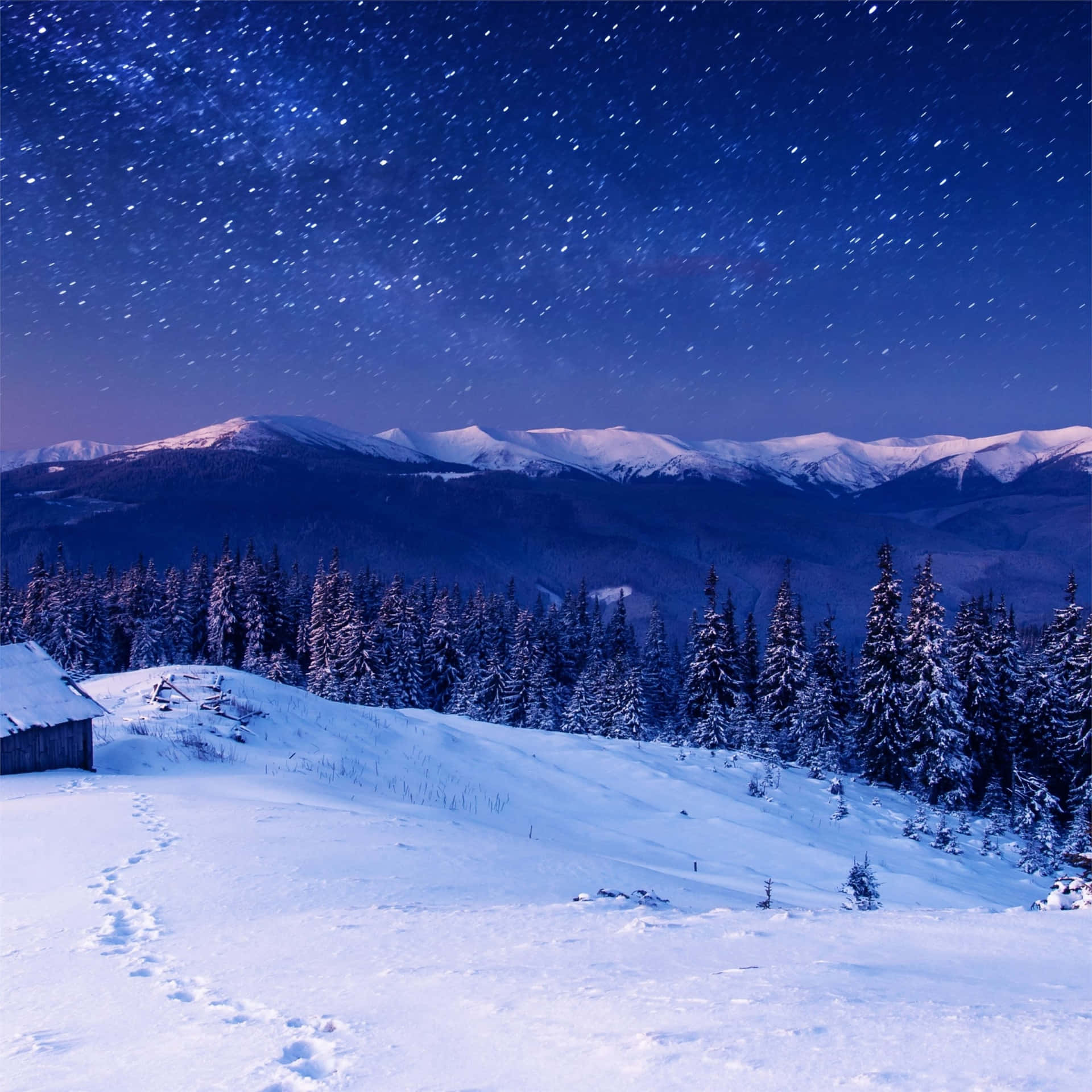 A Snowy Landscape With A Cabin And Stars Wallpaper
