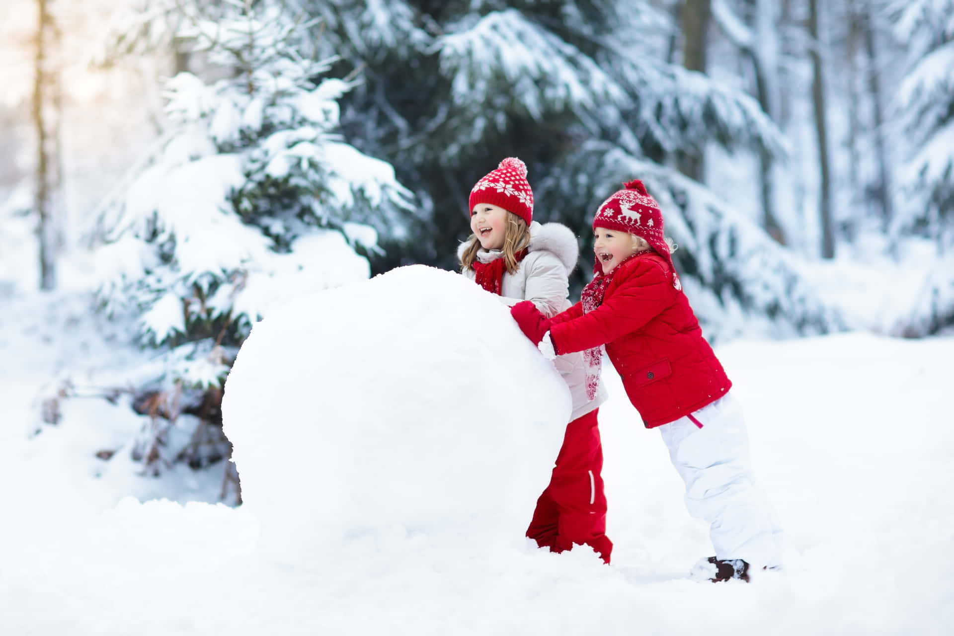 Two Children Playing In The Snow With A Snowman
