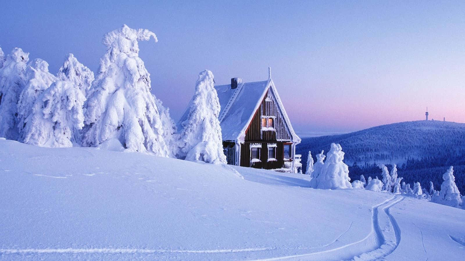 A House Is Covered In Snow On A Snowy Hill Wallpaper