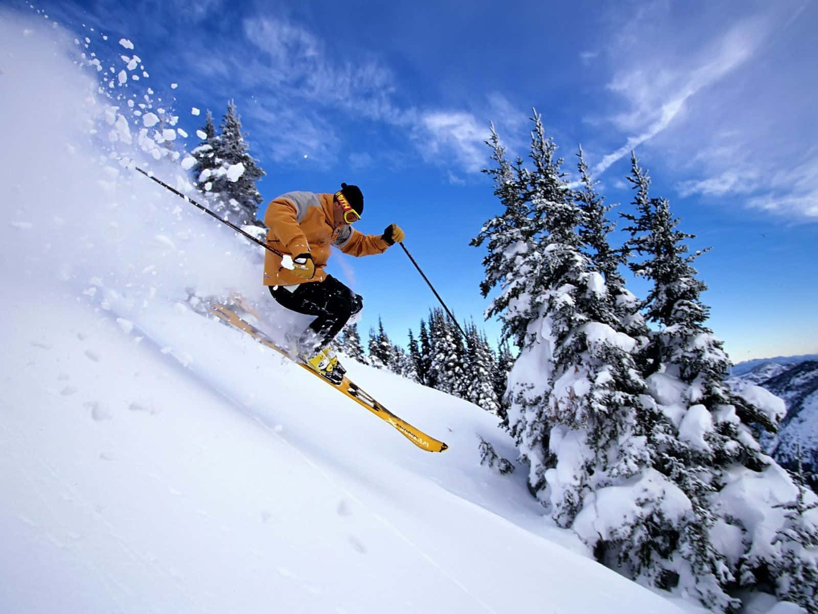 Skier gliding down the snow-covered mountain slope Wallpaper