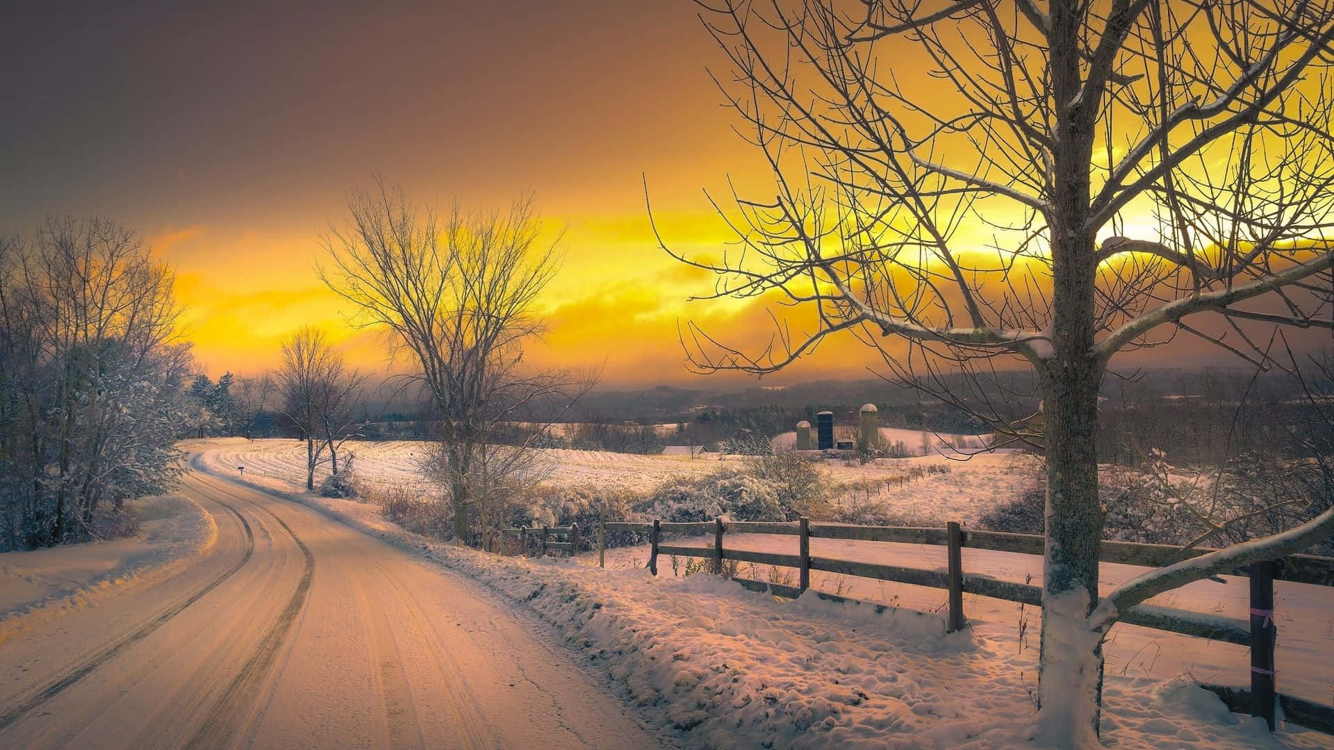 Majestic Winter Sunset Amidst a Snowy Landscape Wallpaper