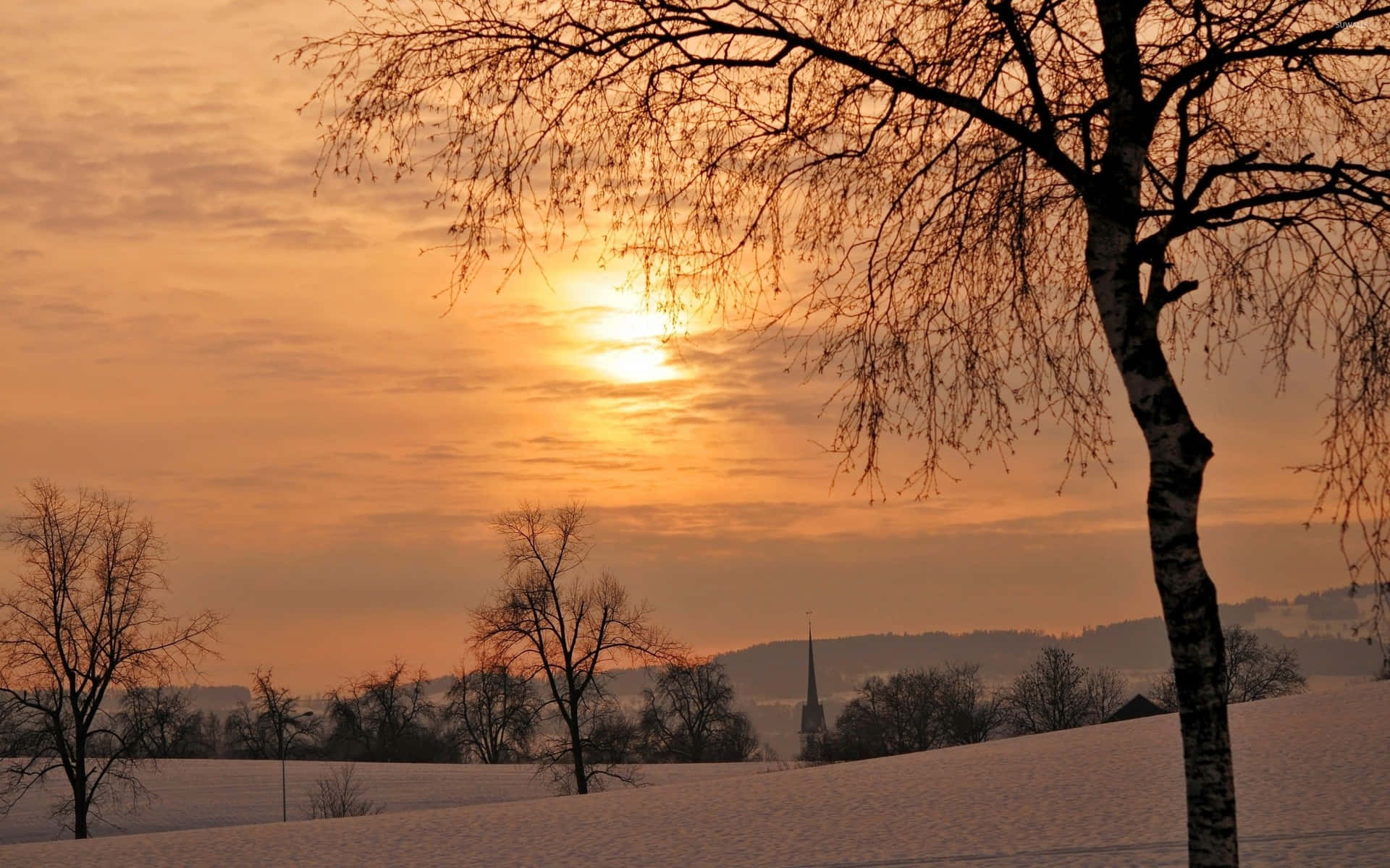 Caption: Majestic Winter Sunset Over Snow-Covered Landscape Wallpaper