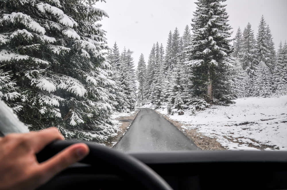 Winter Wonderland: Driving Safely Through Snowy Roads Wallpaper