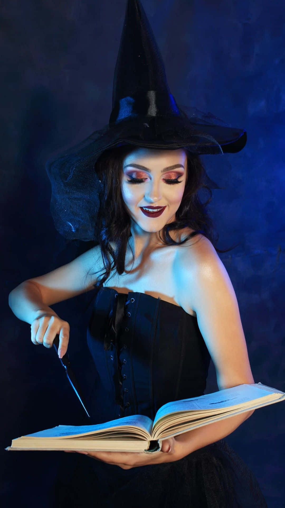 Elegant Witch Costume for a Magical Halloween Celebration Wallpaper
