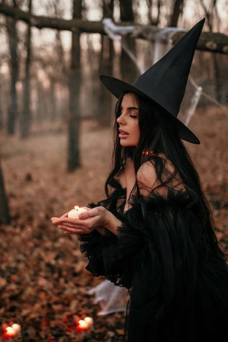 Enchanting Witch Casting a Spell in a Stylish Costume Wallpaper