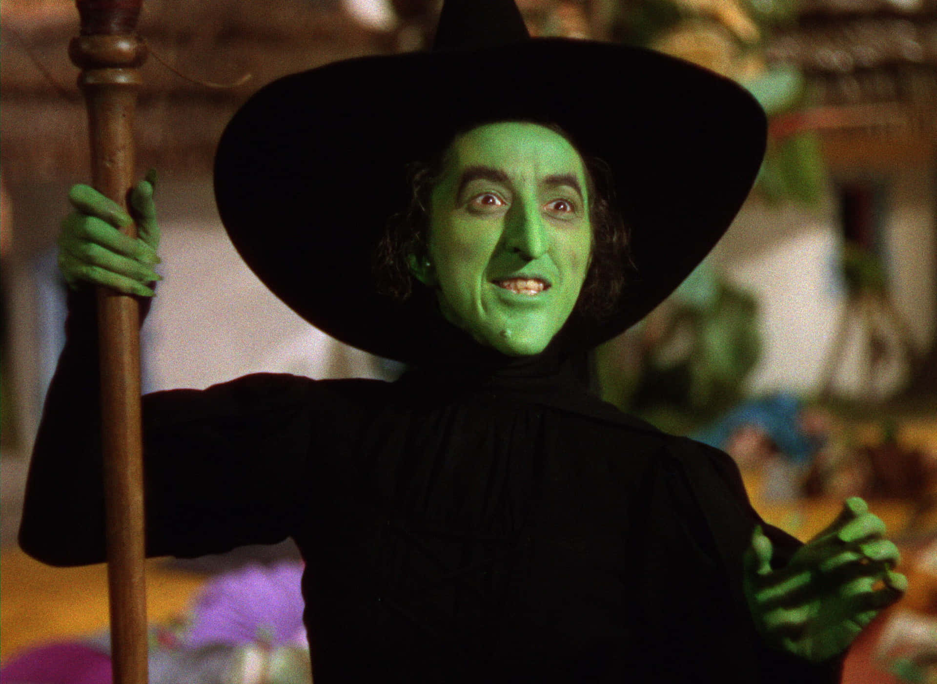 A Woman Dressed In Green Holding A Broom