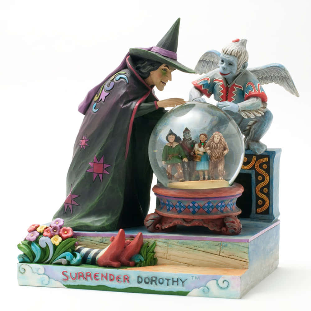 A Figurine Of A Wizard And A Witch With A Snow Globe