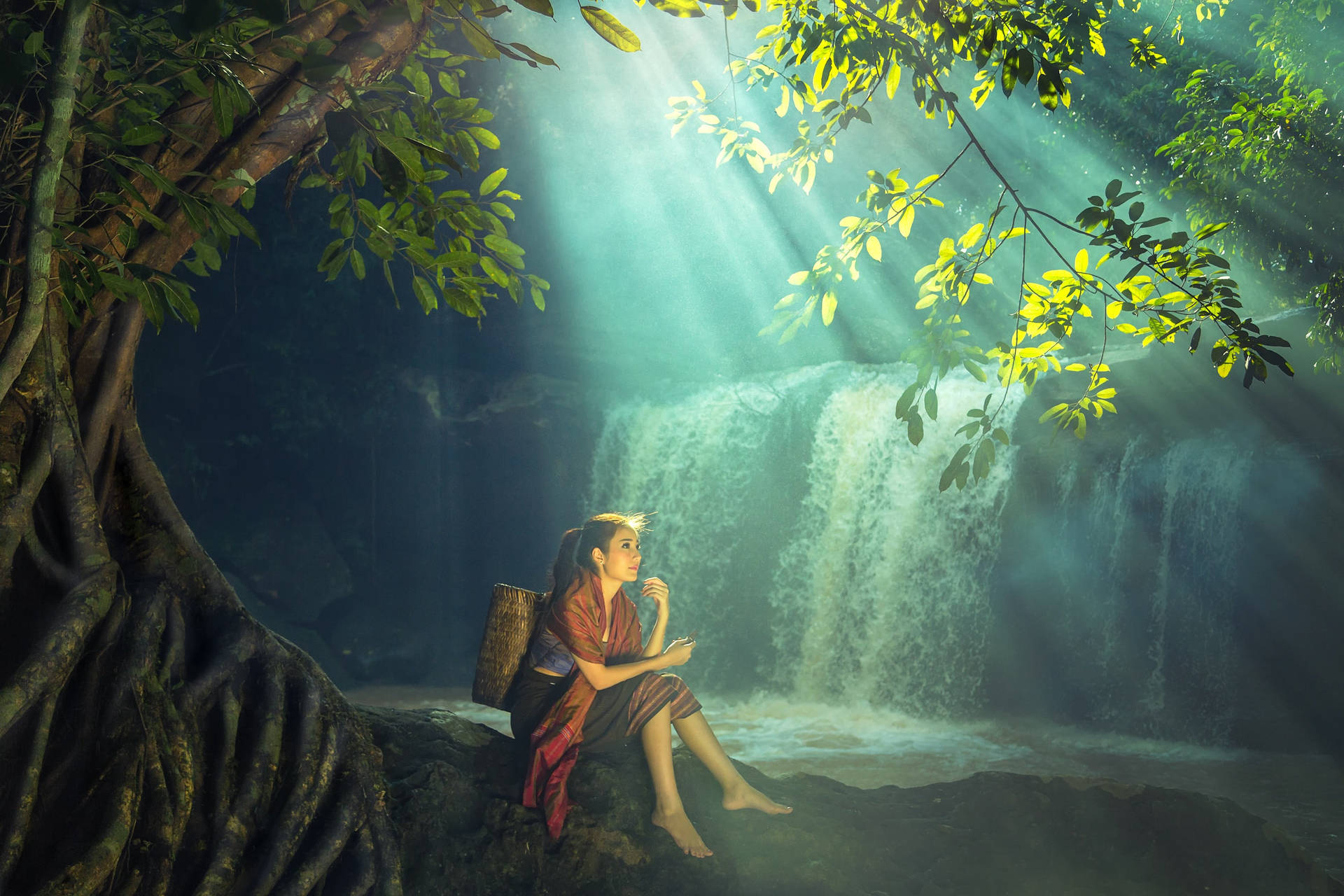 Majestic Serenity: Woman at a Beautiful Waterfall Wallpaper