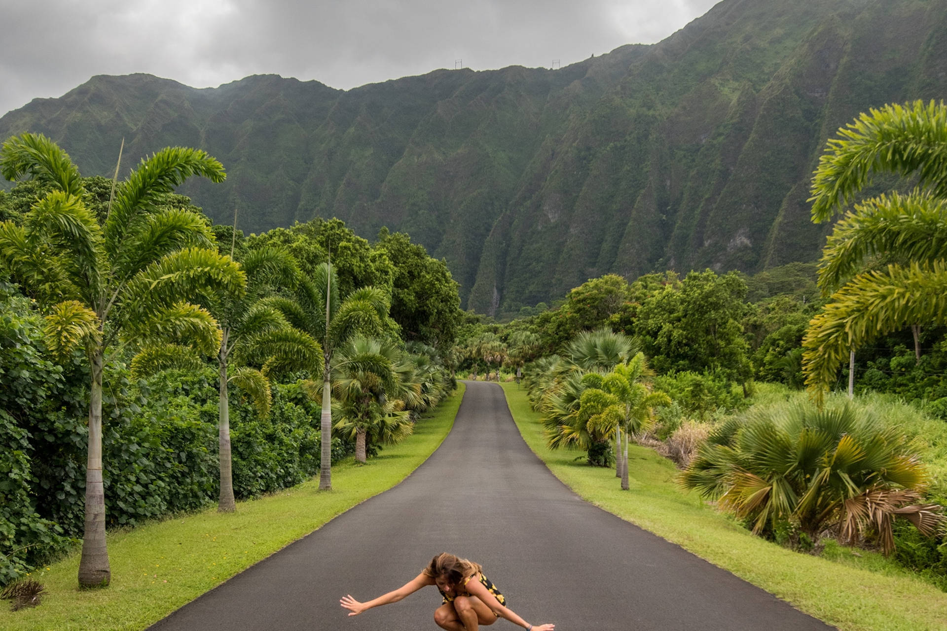 Woman Crouching In Oahu Botanical Garden Wallpaper
