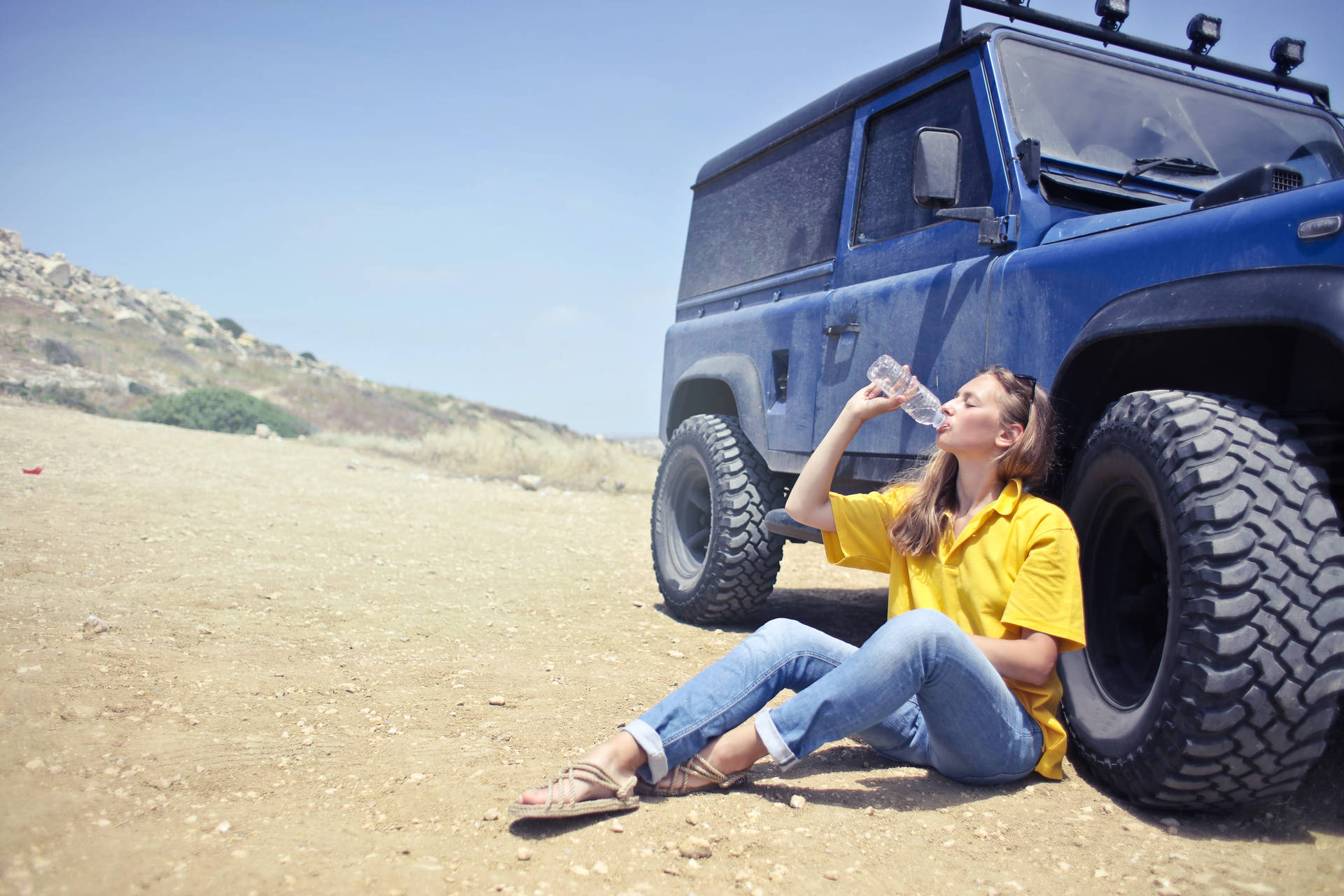 Woman Drinking Water Beside A Car Wallpaper