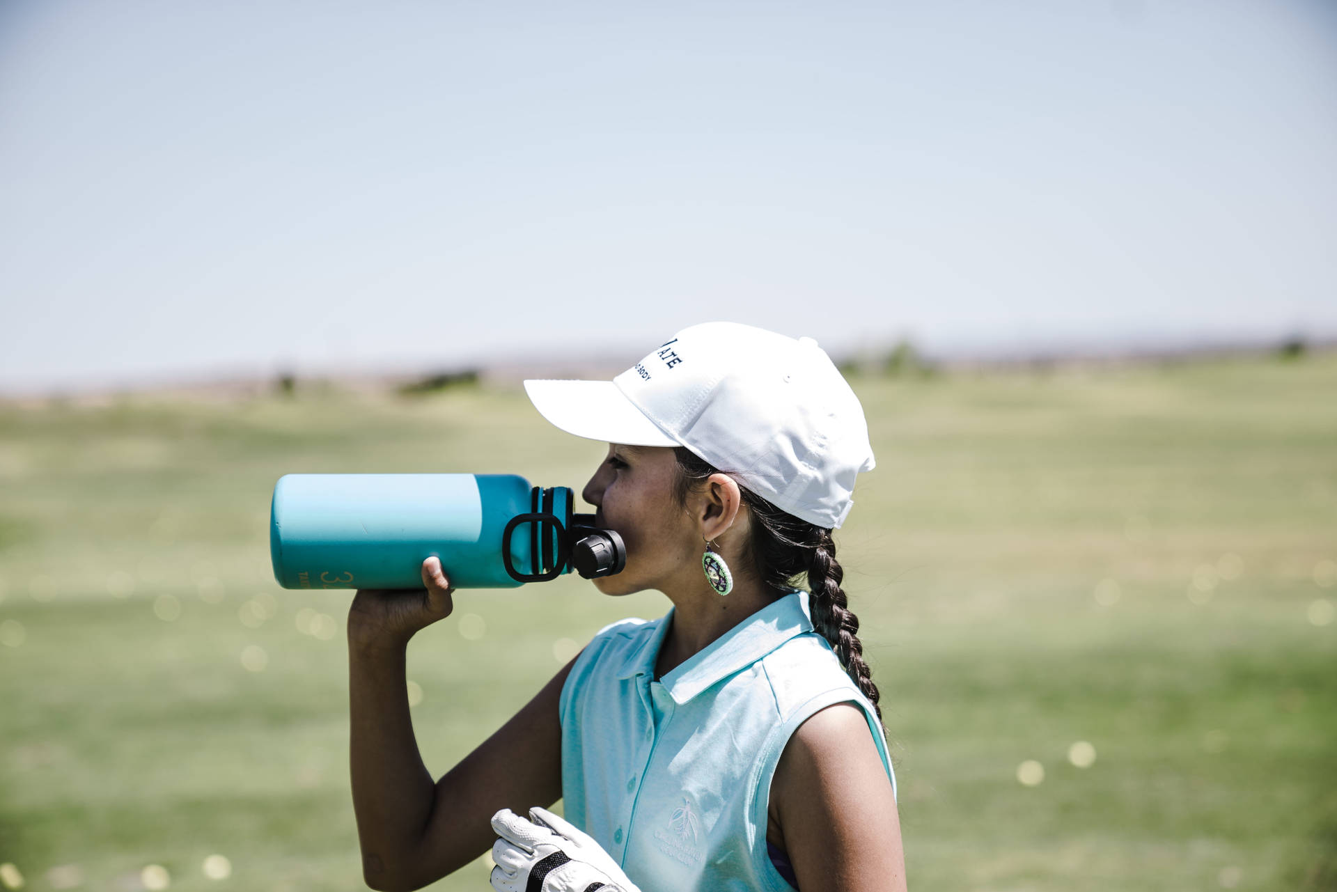 Kvinde drikker vand på golfbane Wallpaper