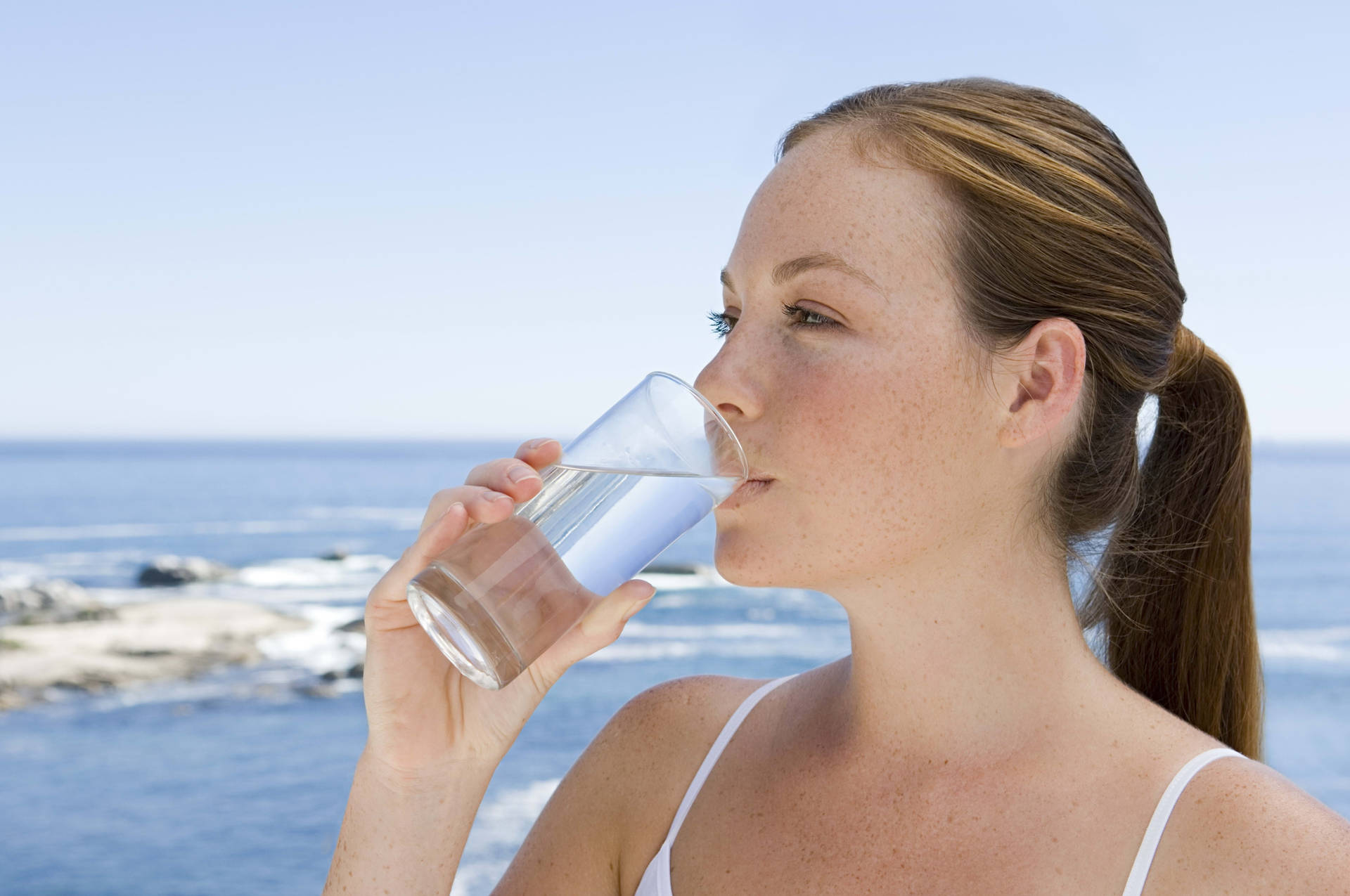 Woman Drinking Water On The Beach Wallpaper