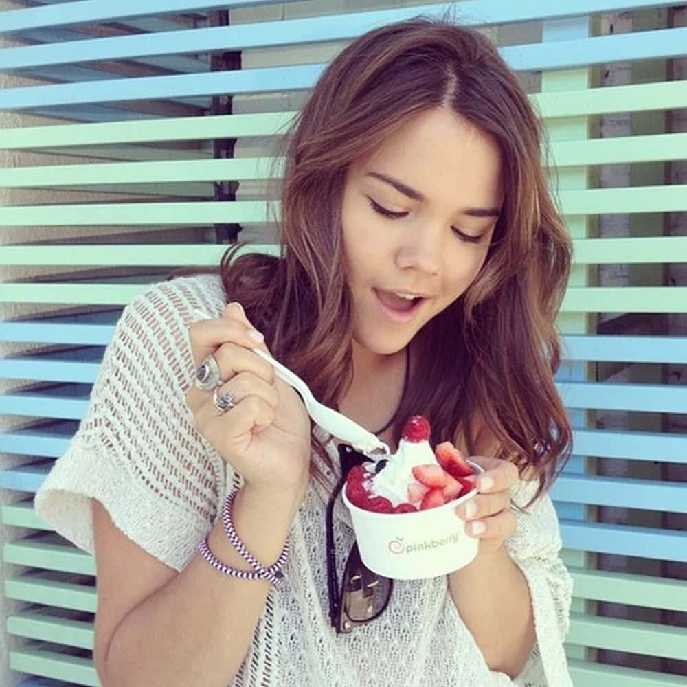 Woman Enjoying Frozen Yogurt Outdoors Wallpaper
