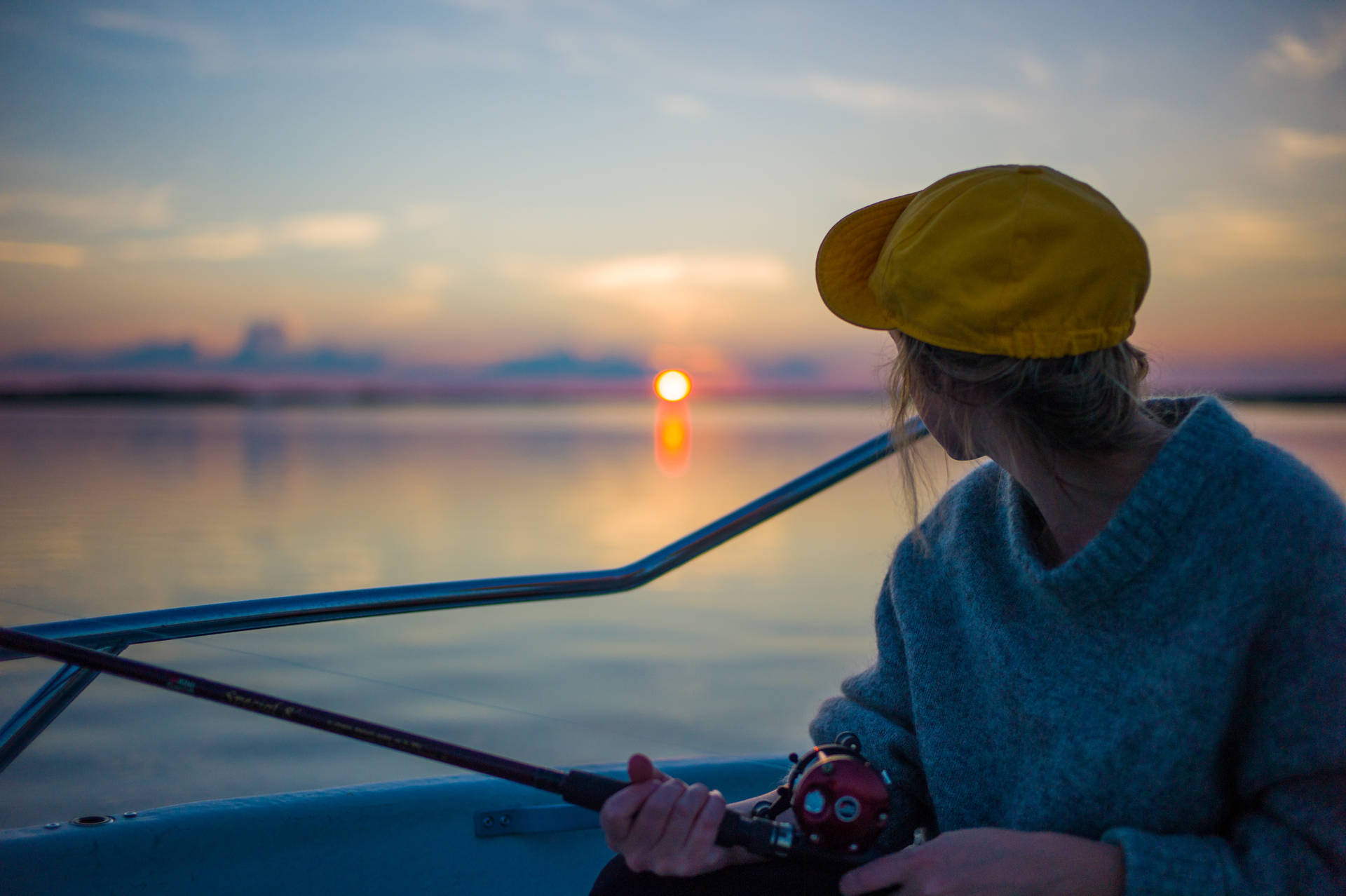 Woman Fishing At Finland Sunset
