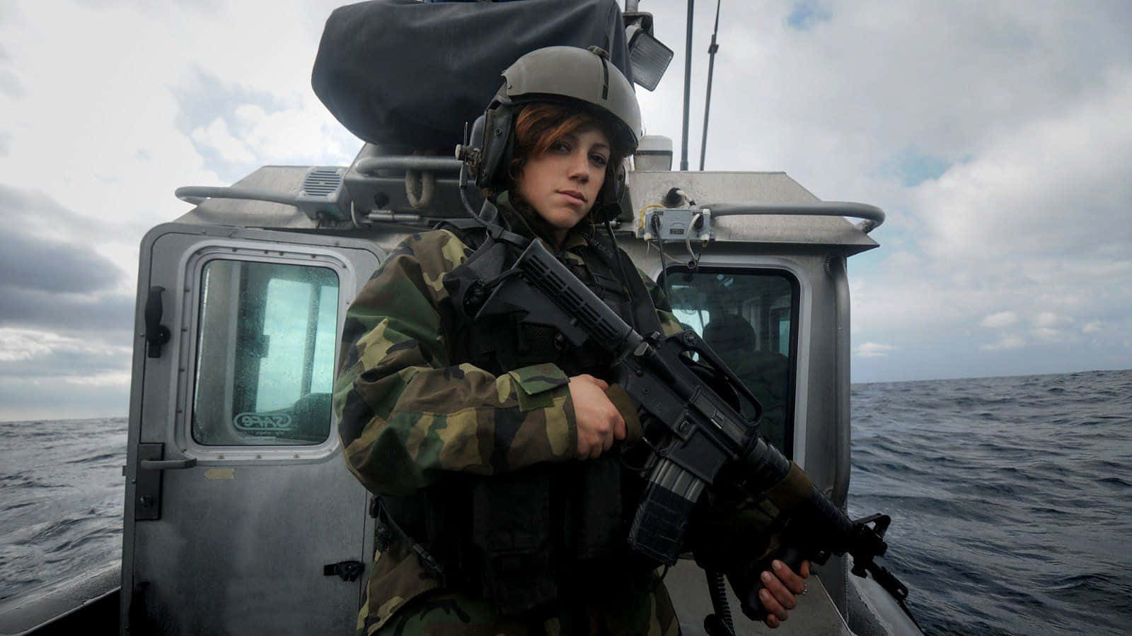 Woman Holding Gun Uniform On Boat Wallpaper