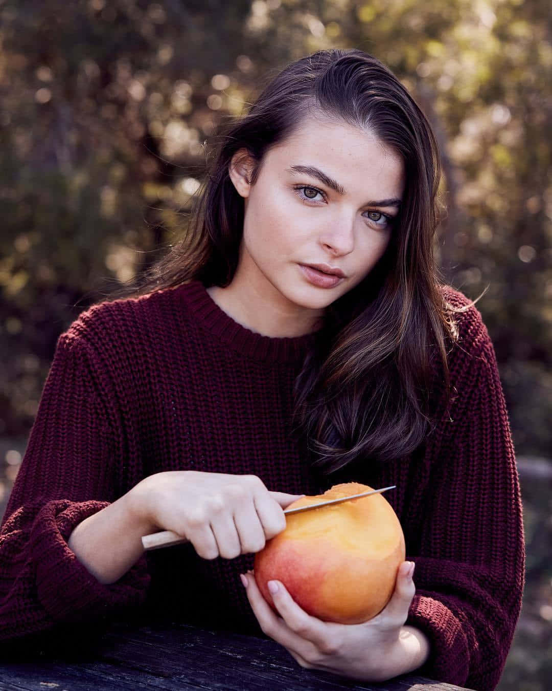 Woman Holding Peach Outdoors Wallpaper