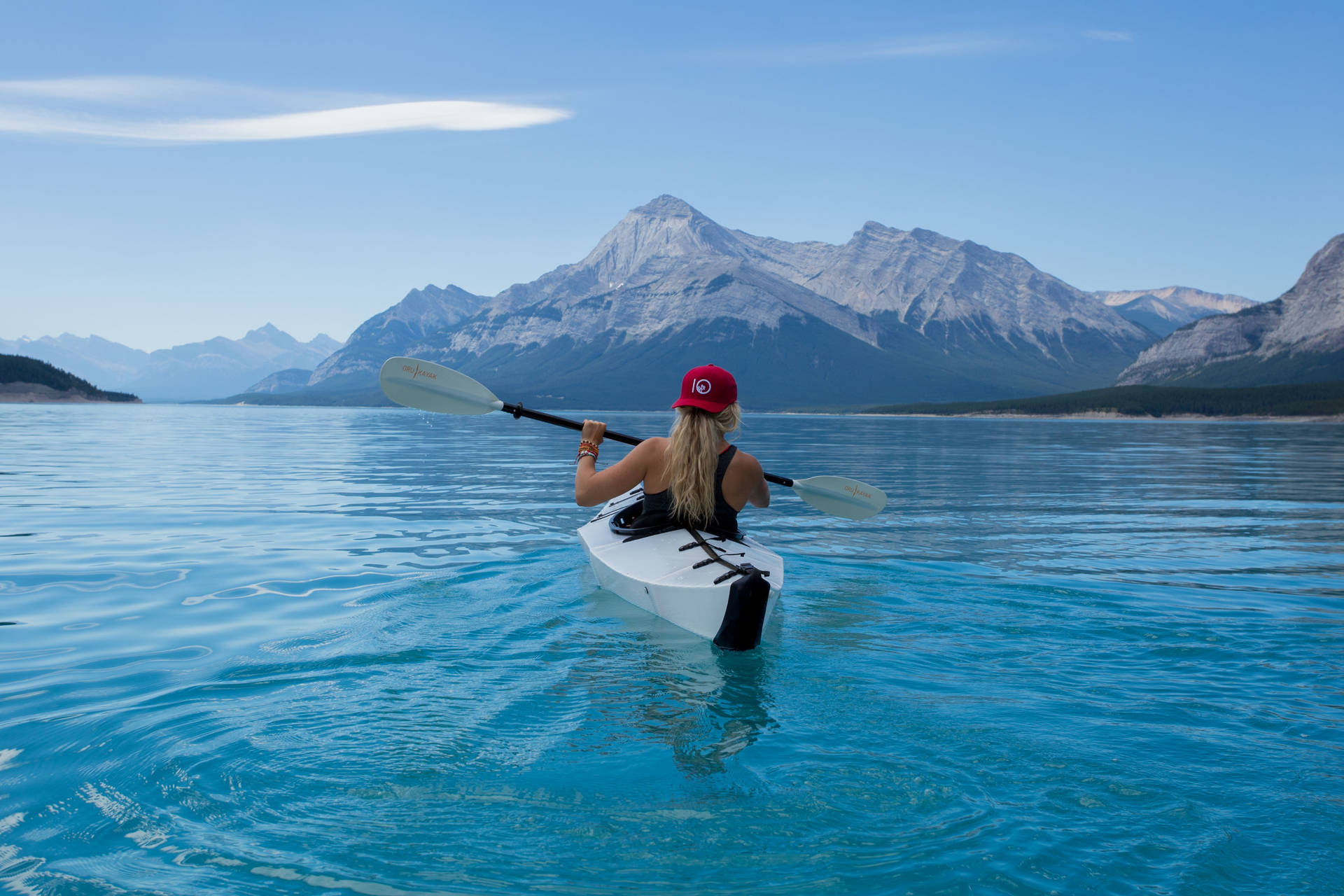 Mujerhaciendo Kayak Sobre Hermosas Aguas Azules. Fondo de pantalla